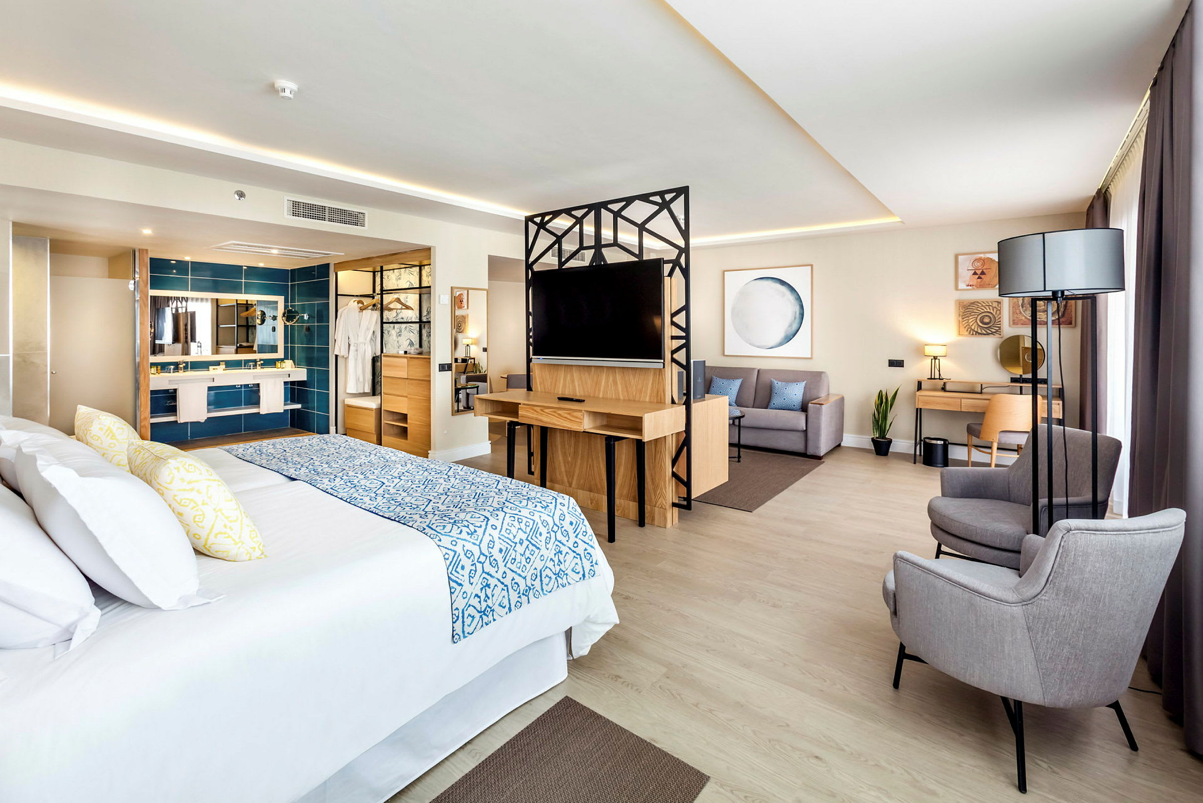 Ett hotellrum med en stor säng, sittgrupp och skrivbord. (AI-genererad text)