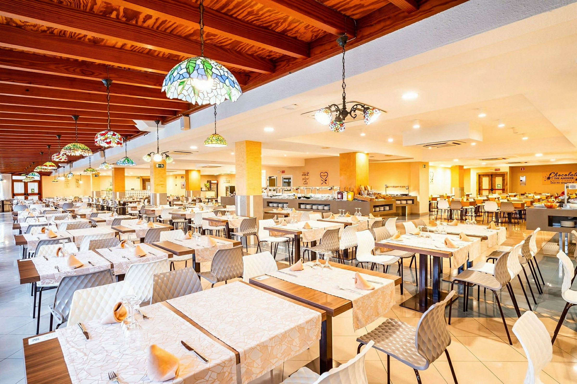 En rymlig restaurang med dukade bord och färgglada taklampor. (AI-genererad text)