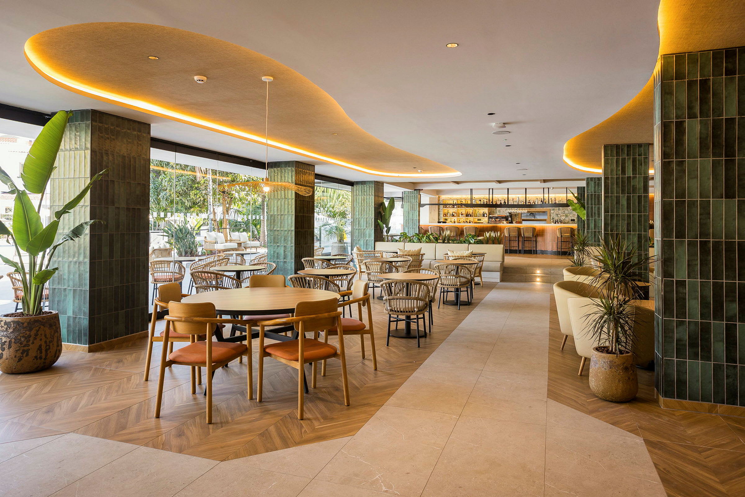 En elegant restaurang med moderna möbler och inredning, belägen inomhus med gröna detaljer och stor bar i bakgrunden. (AI-genererad text)