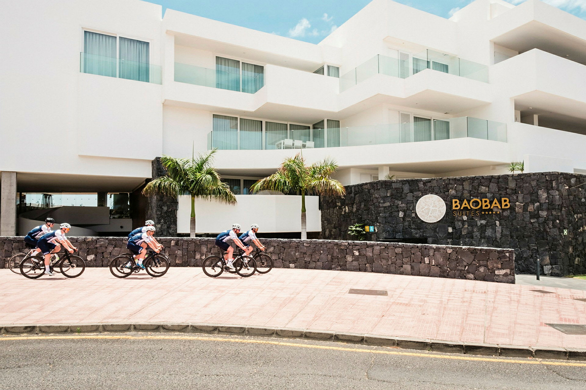 Cyklar passerar framför ett hotell med modern arkitektur. (AI-genererad text)