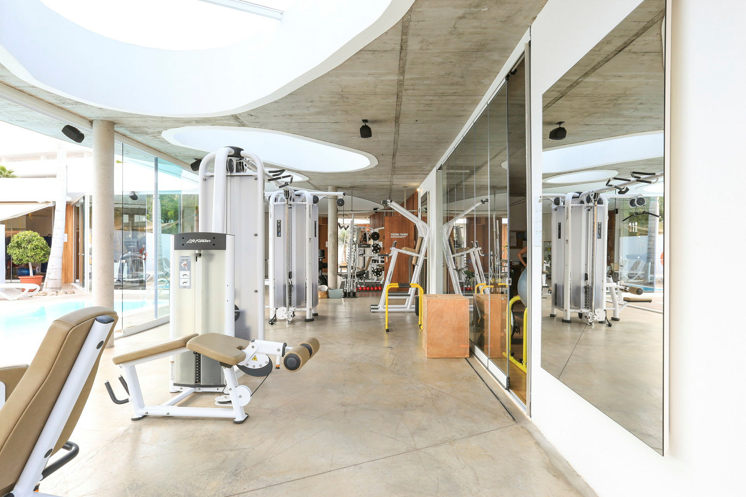 Gym med träningsutrustning och spegelvägg. (AI-genererad text)