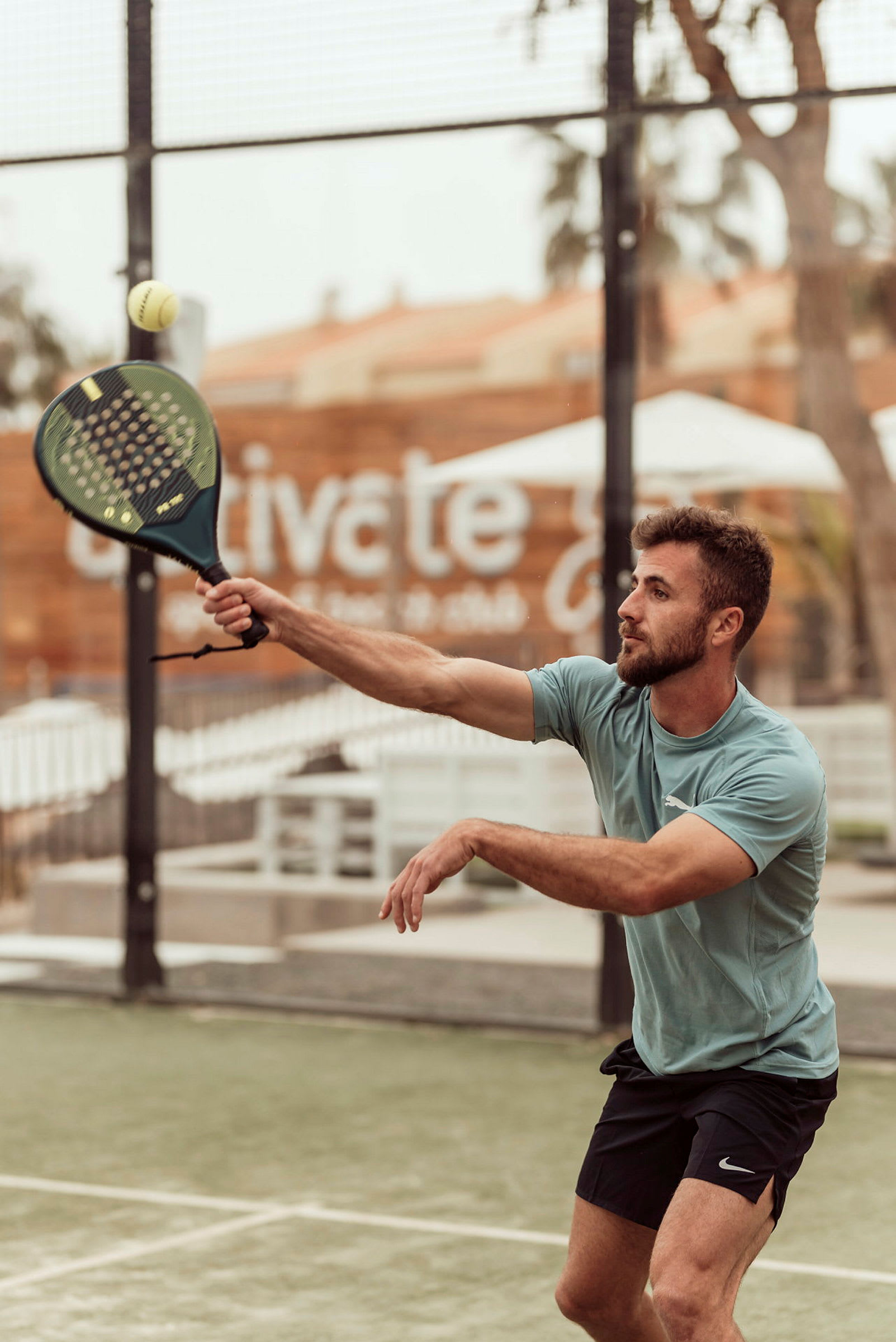 Person spelar padel och sträcker sig efter bollen. (AI-genererad text)