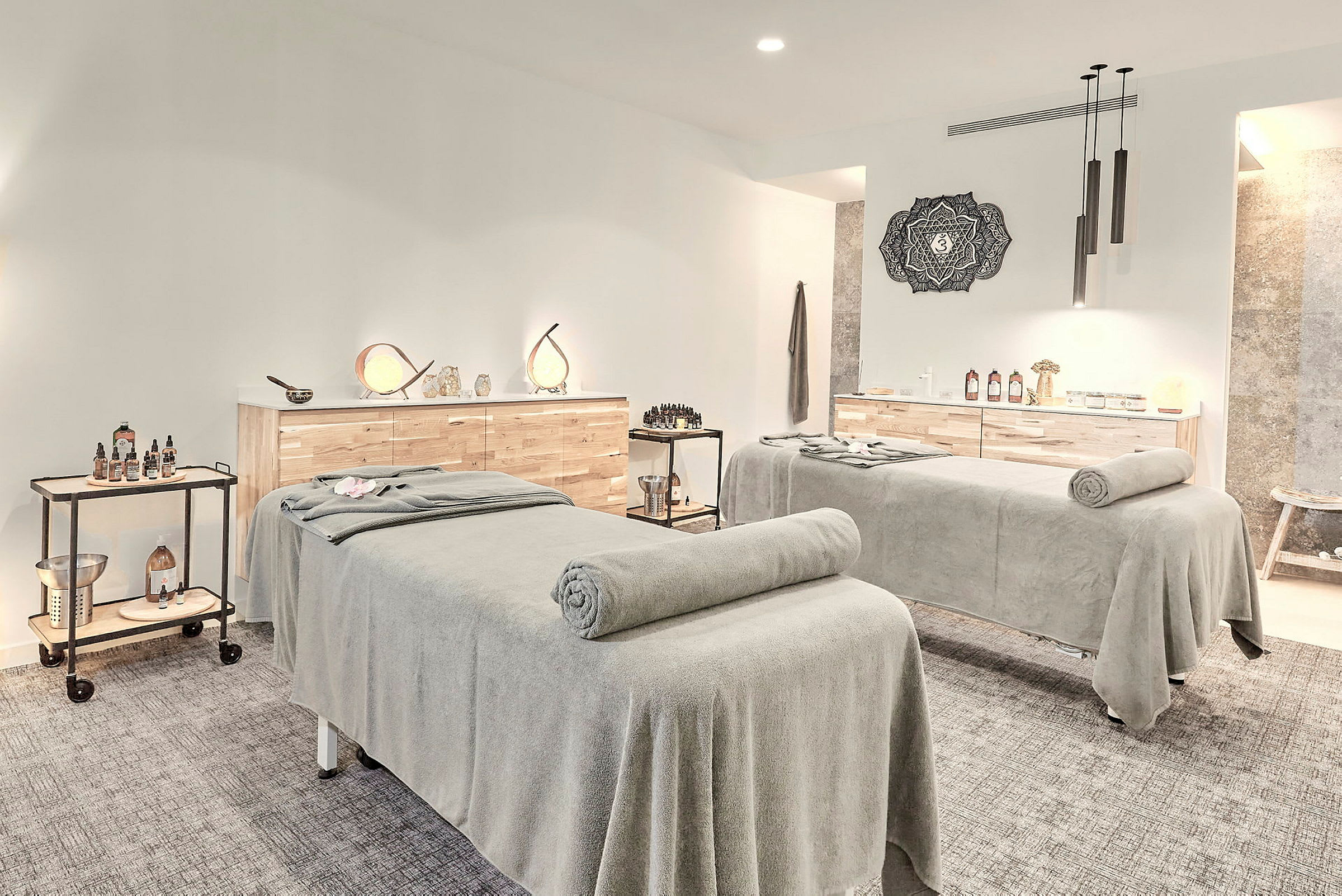 Två massagebänkar i ett ljust behandlingsrum. (AI-genererad text)