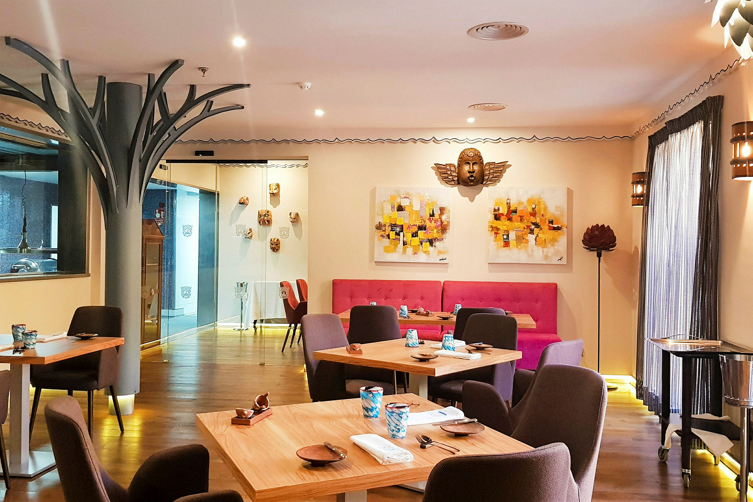 Bild av en smakfullt inredd restaurang med träbord och färgglada väggdekorationer. (AI-genererad text)