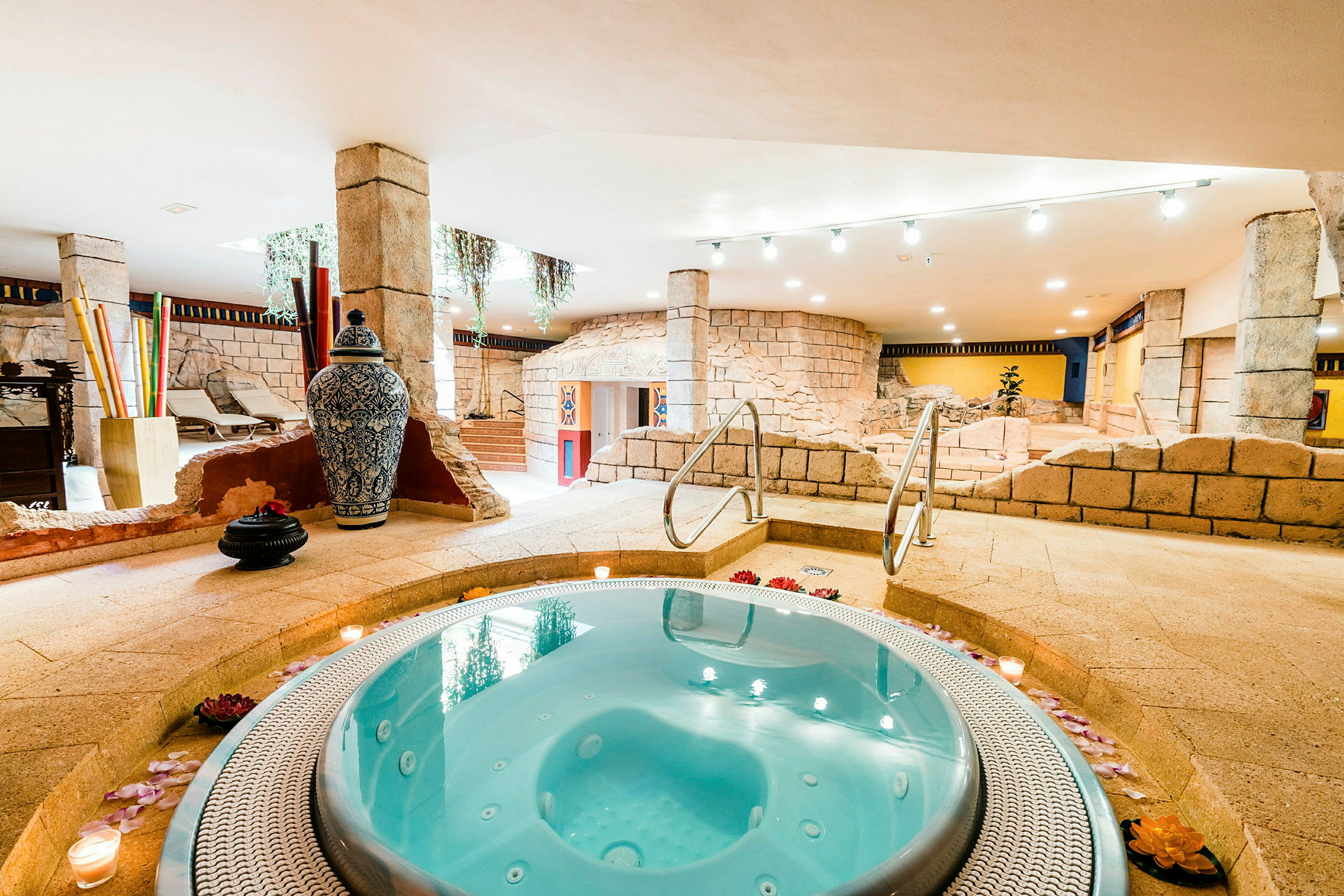 Bild av en bubbelpool i ett inomhusspa med steninredning och dekorativa föremål. (AI-genererad text)