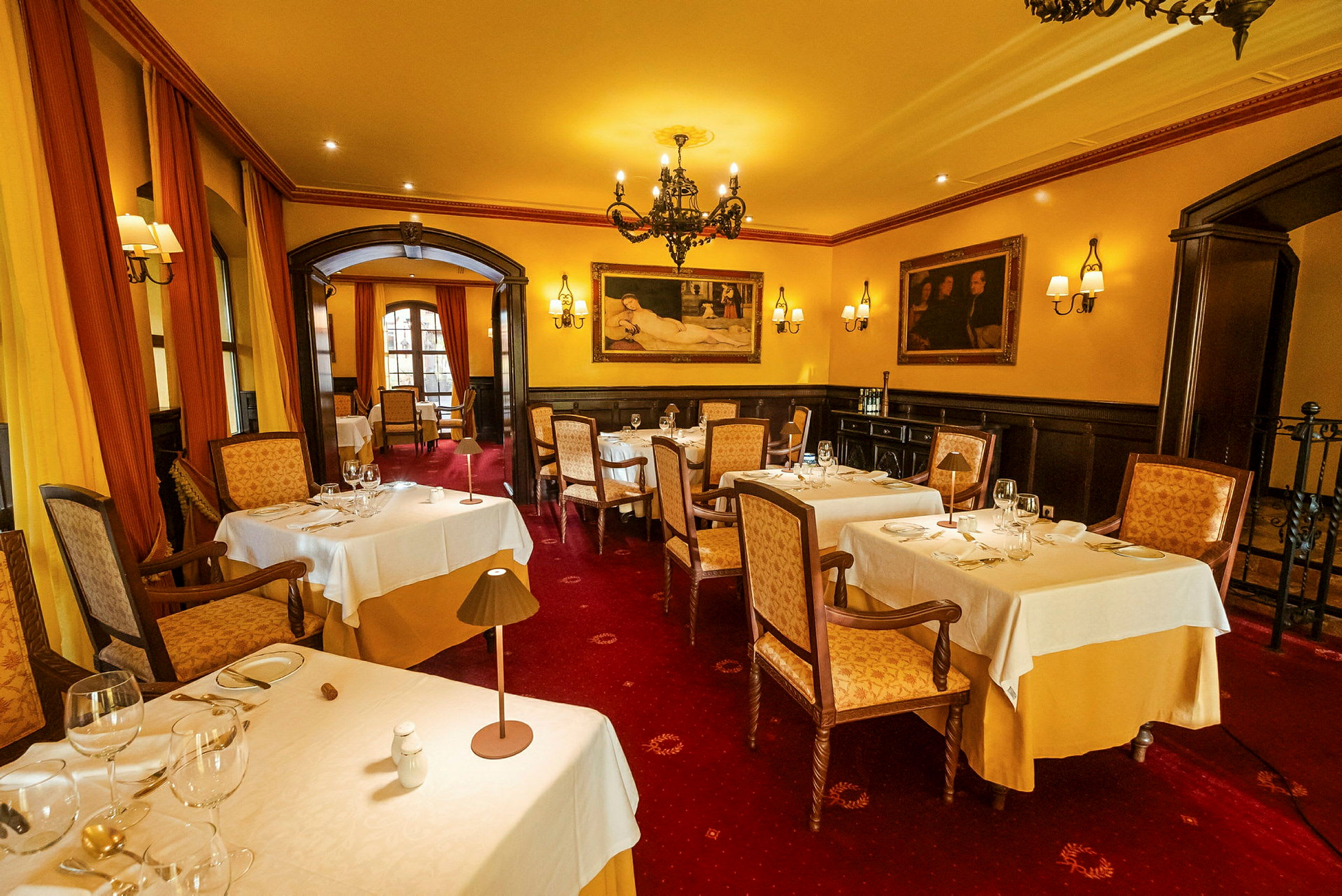 En elegant restaurang med dukade bord, mjukt belysning och konstverk på väggarna. (AI-genererad text)