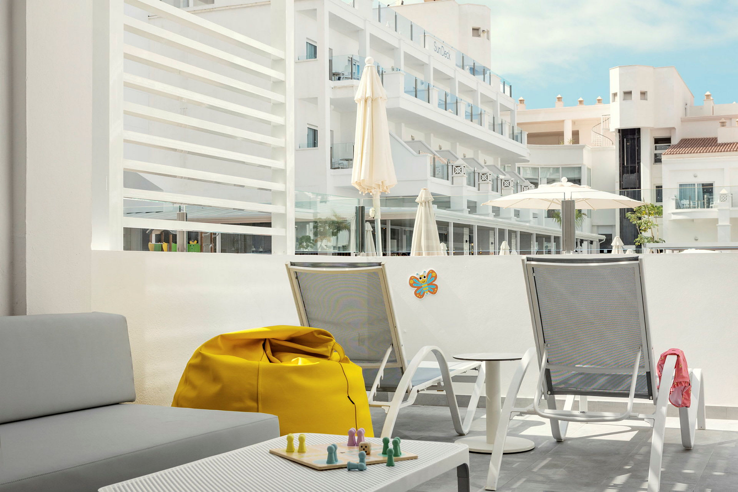 Bild på en hotellterrass med sittmöbler och en utsikt över byggnader. (AI-genererad text)