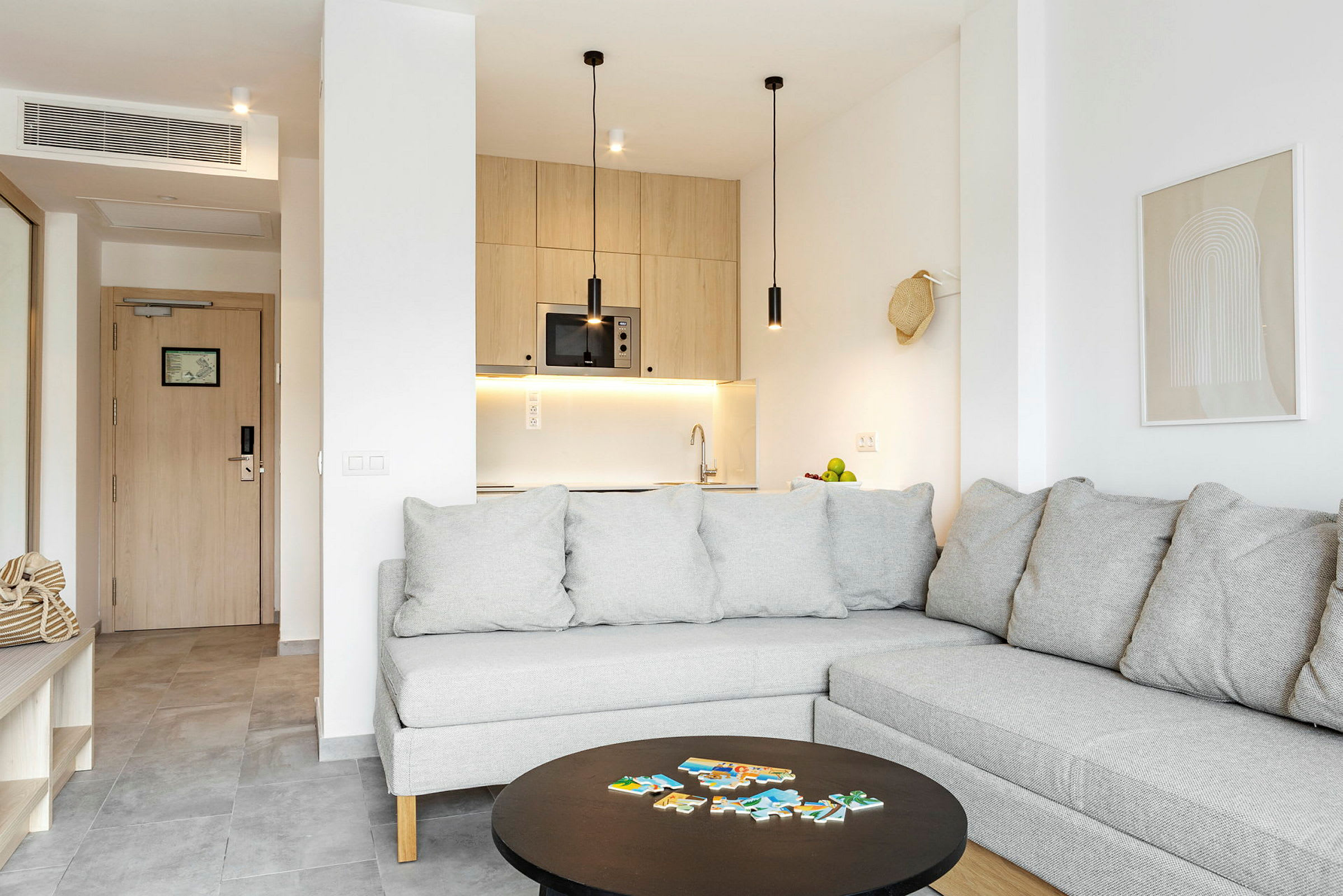 En modern lägenhet med grå soffa och en öppen köksdel. (AI-genererad text)