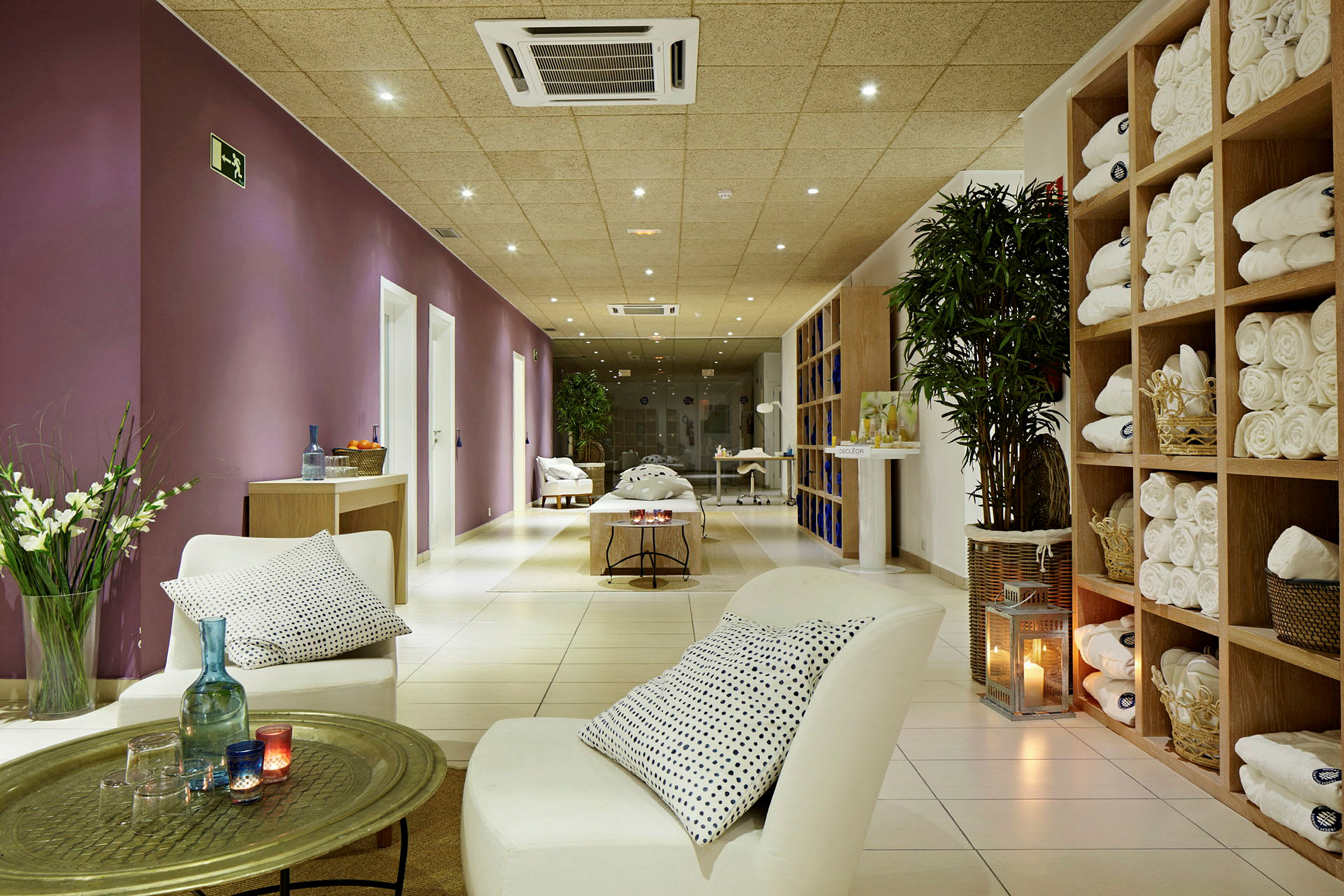 Avslappnande spa-miljö med stolar, bord och handdukar. (AI-genererad text)