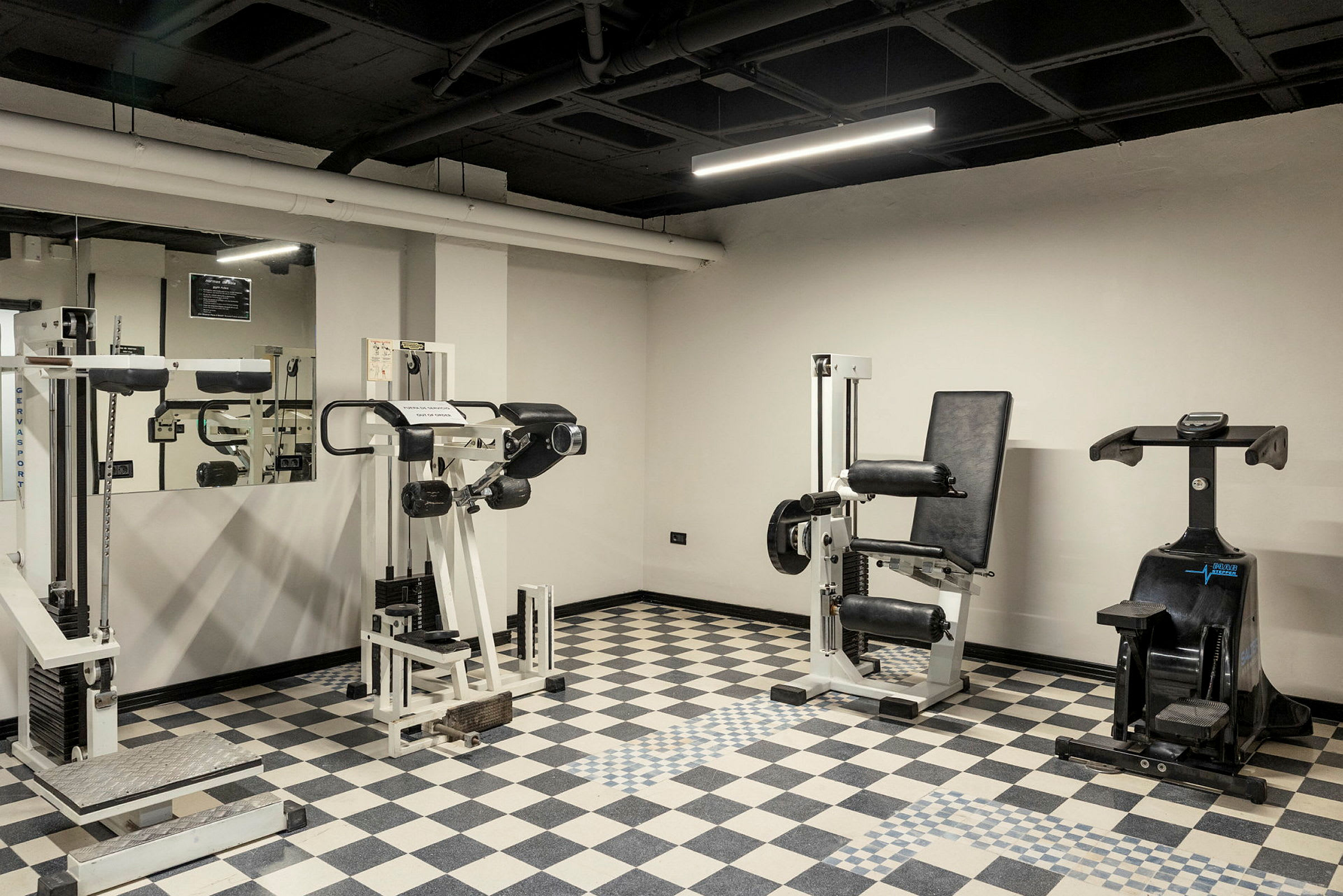 Ett gym med träningsmaskiner och spegelvägg. (AI-genererad text)