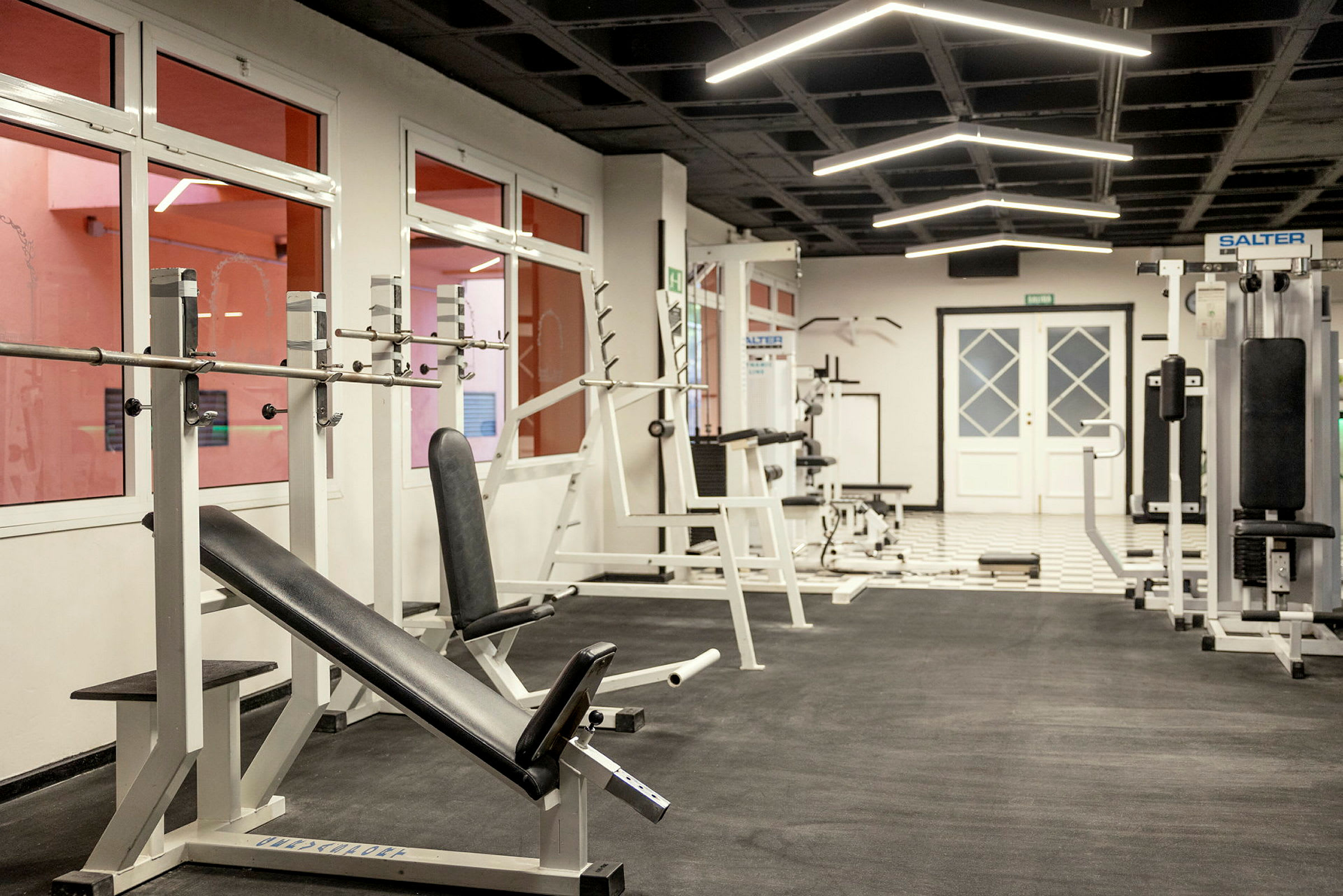 Ett gym med olika träningsmaskiner och utrustning. (AI-genererad text)