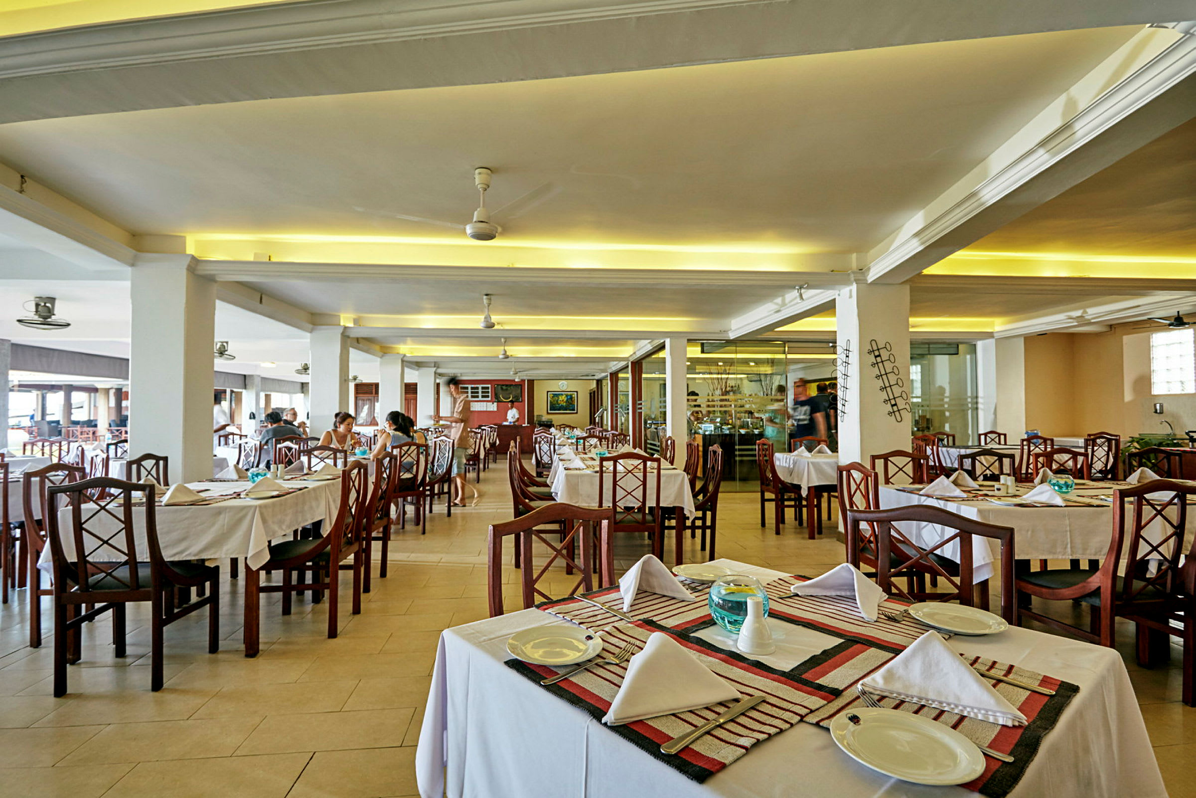 Interiör av en restaurang med dukade bord och stolar. (AI-genererad text)