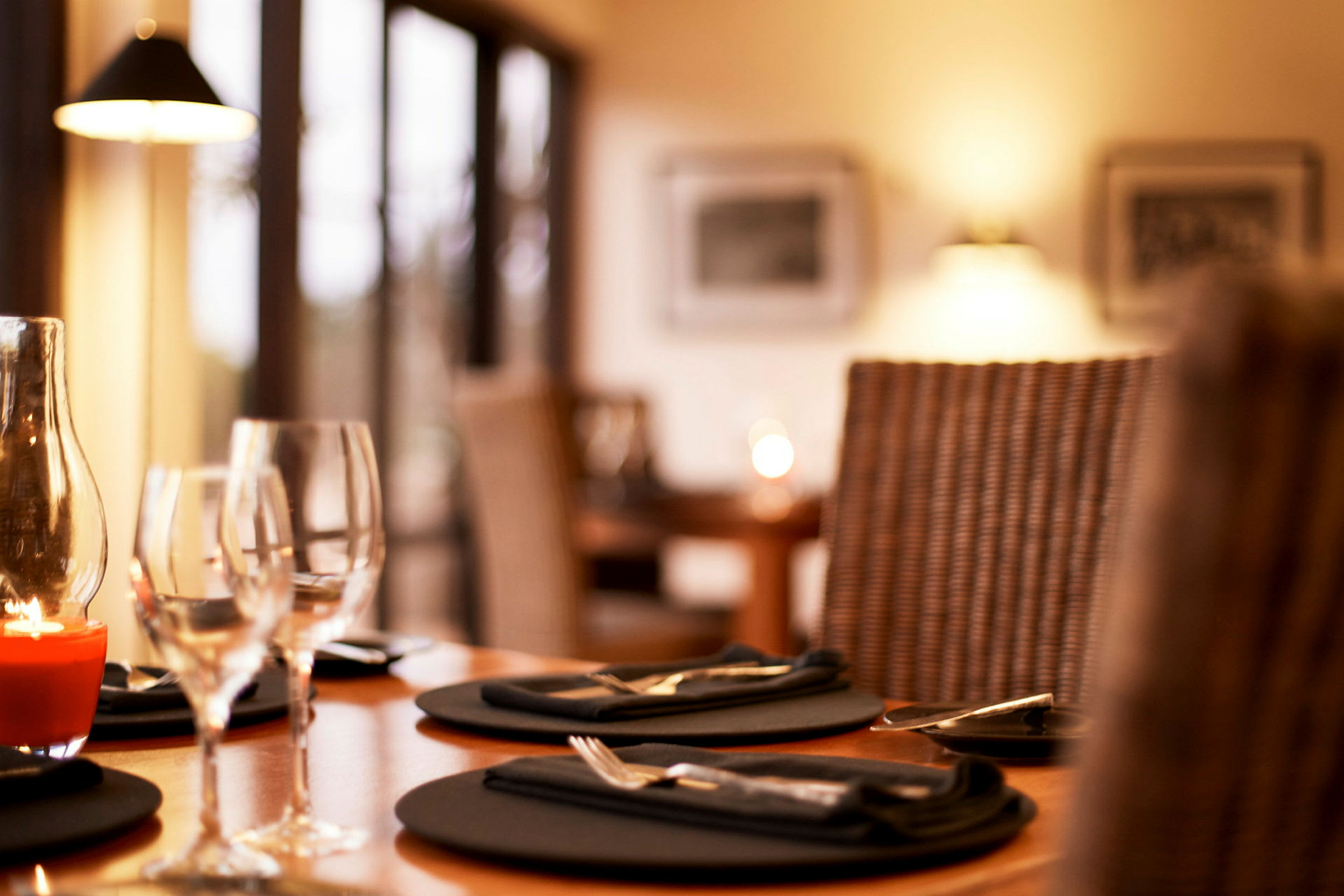En bild av ett dukat restaurangbord med glas och tallrikar. (AI-genererad text)