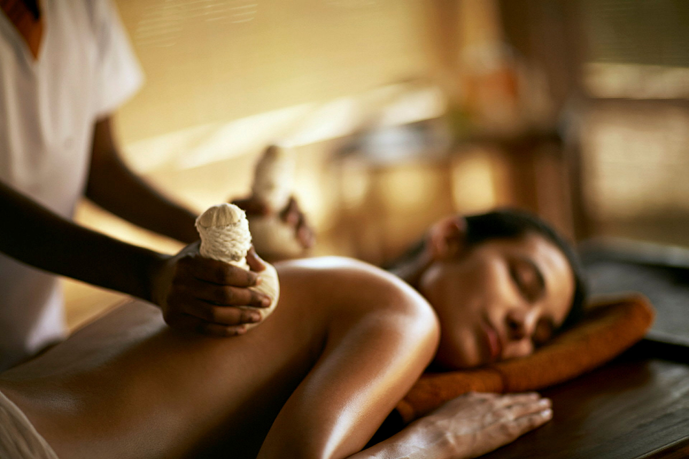 Person får massage med kortade örtpåsar på ryggen. (AI-genererad text)