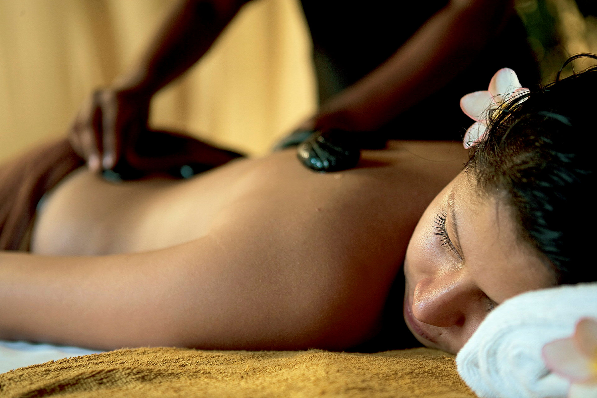 En person får en avslappnande massage med varma stenar. (AI-genererad text)