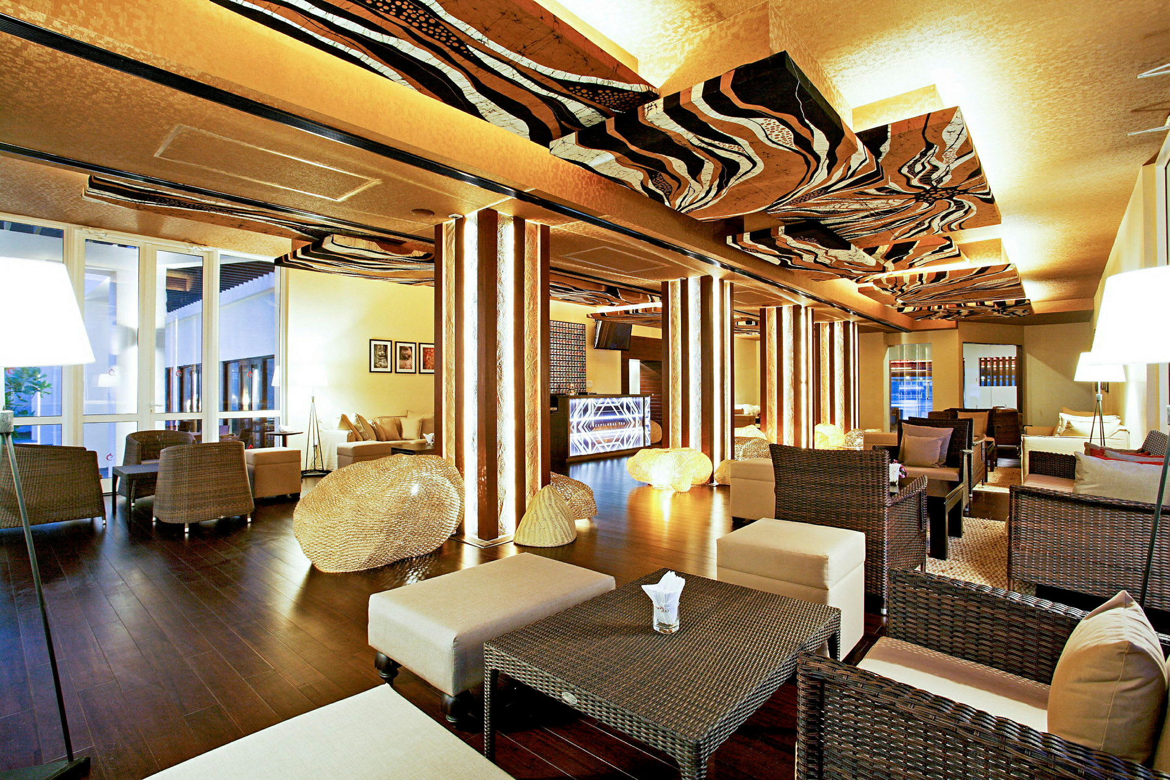 En elegant lounge med modern inredning, korgmöbler, bord och belysning dekorerar rummet. (AI-genererad text)