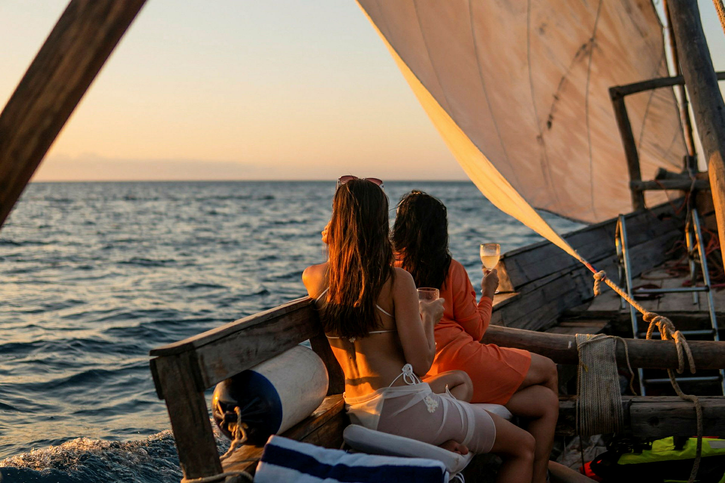 Två personer sitter på en segelbåt med drinken i handen och ser ut över havet. (AI-genererad text)
