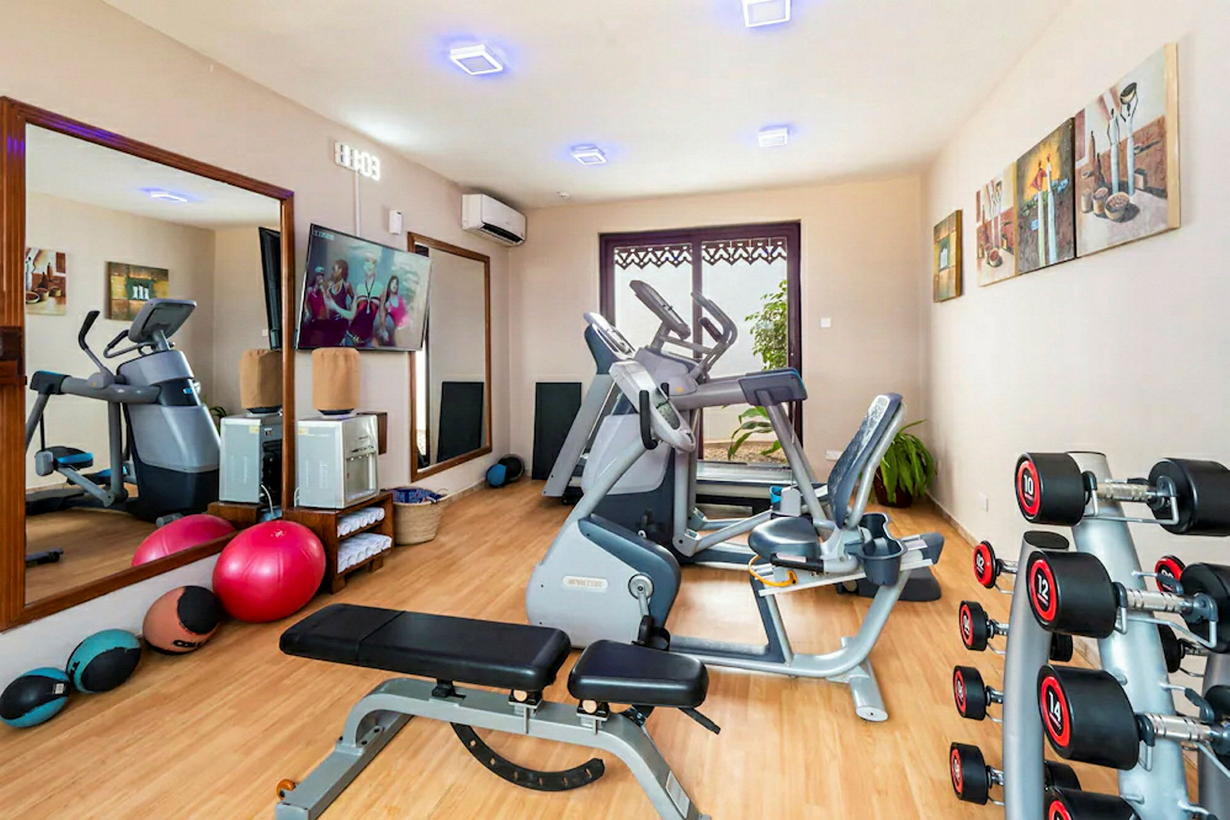 Ett gym med träningsmaskiner och utrustning som hantlar, motionscyklar och träningsbollar. (AI-genererad text)