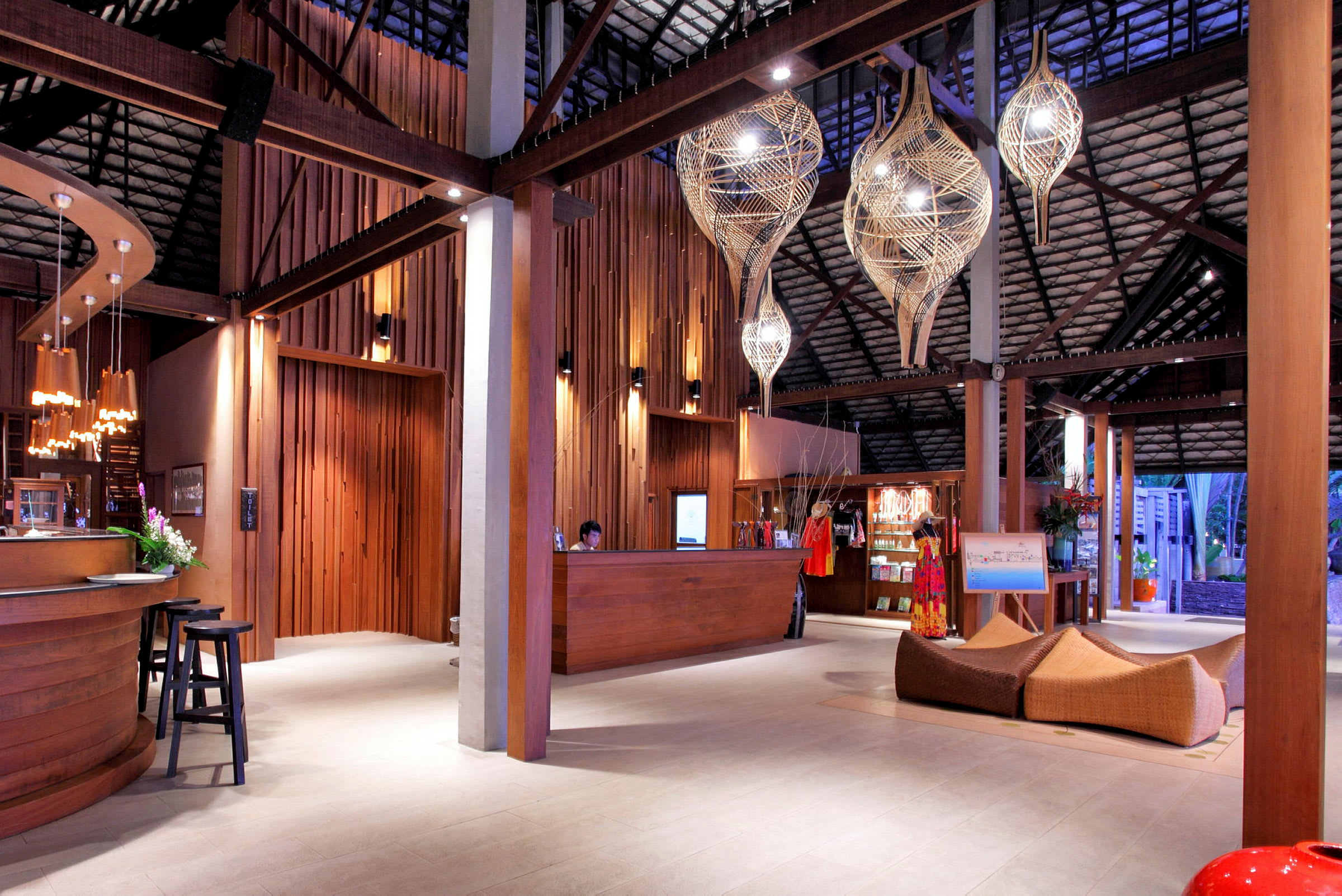 En hotellobby med träinredning, en reception och dekorativa ljusarmaturer. (AI-genererad text)