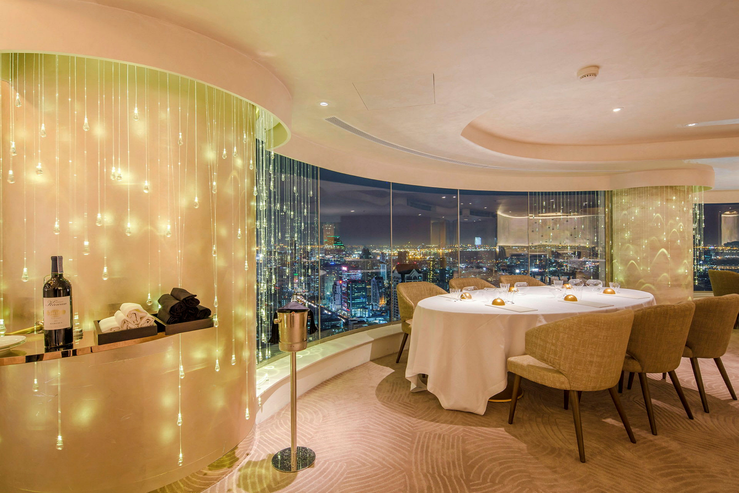 Utsikt över en elegant restaurang med glasfönster och ljusanordning, dekorer på bordet och en flaska vin. (AI-genererad text)