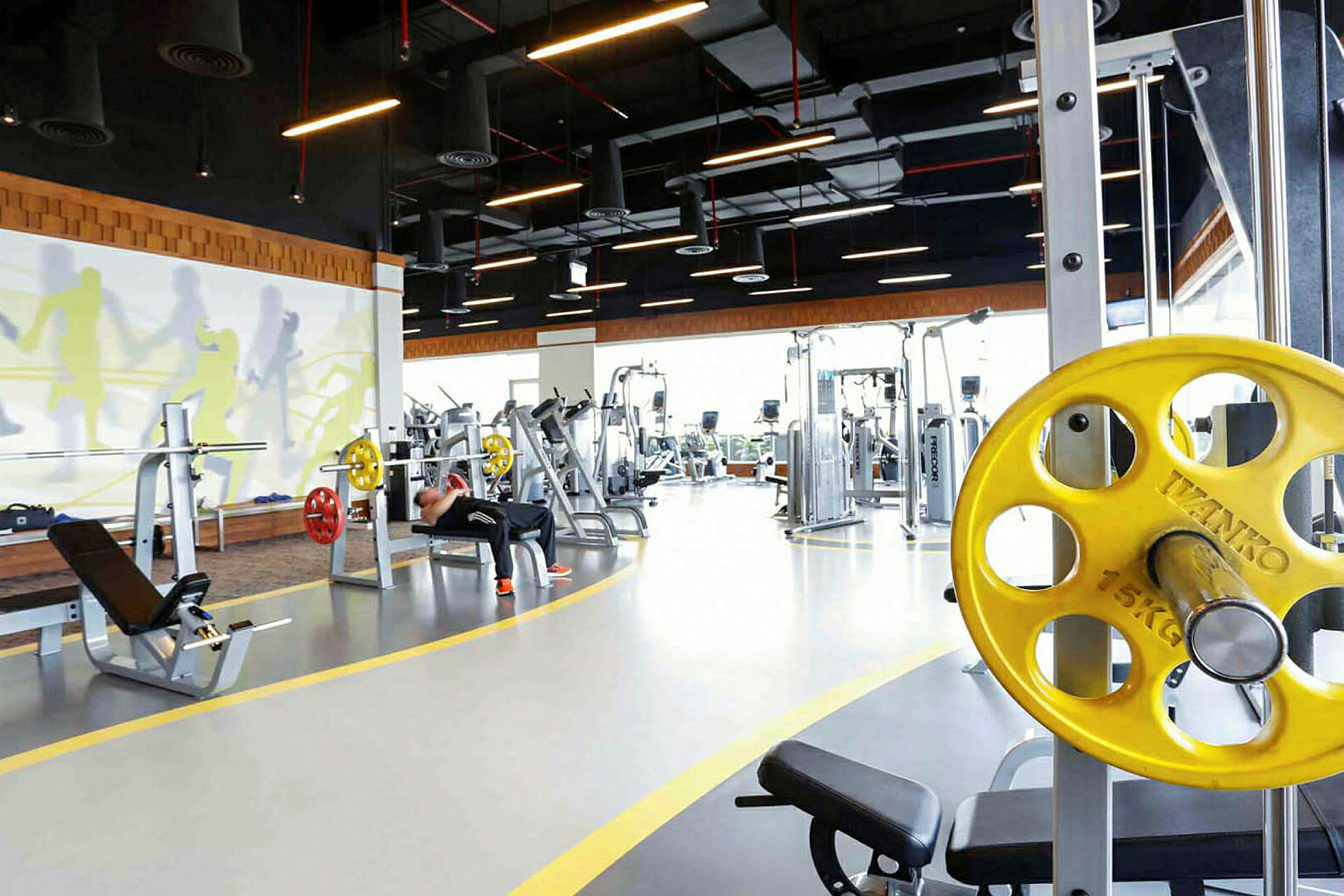 Ett gym med träningsutrustning och en ljus inredning. (AI-genererad text)