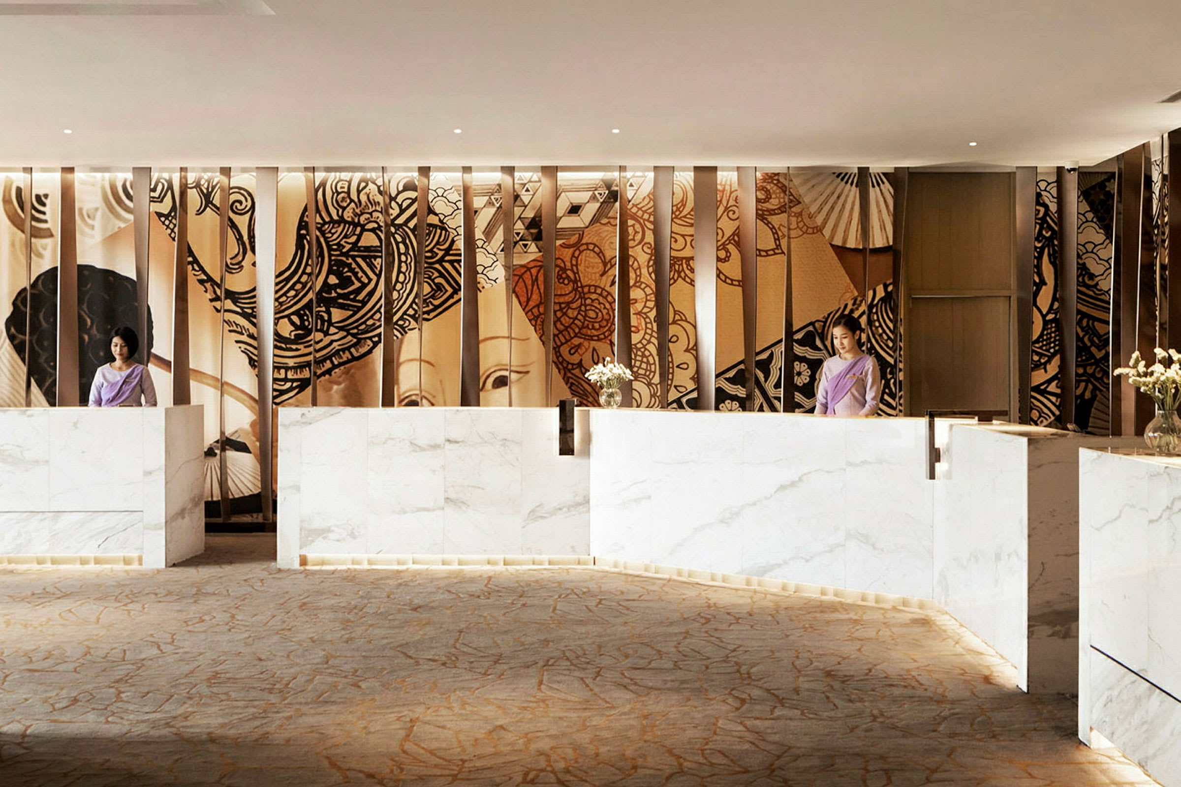 Hotellreception med marmordiskar, dekorativa väggpaneler och en ljus atmosfär. (AI-genererad text)