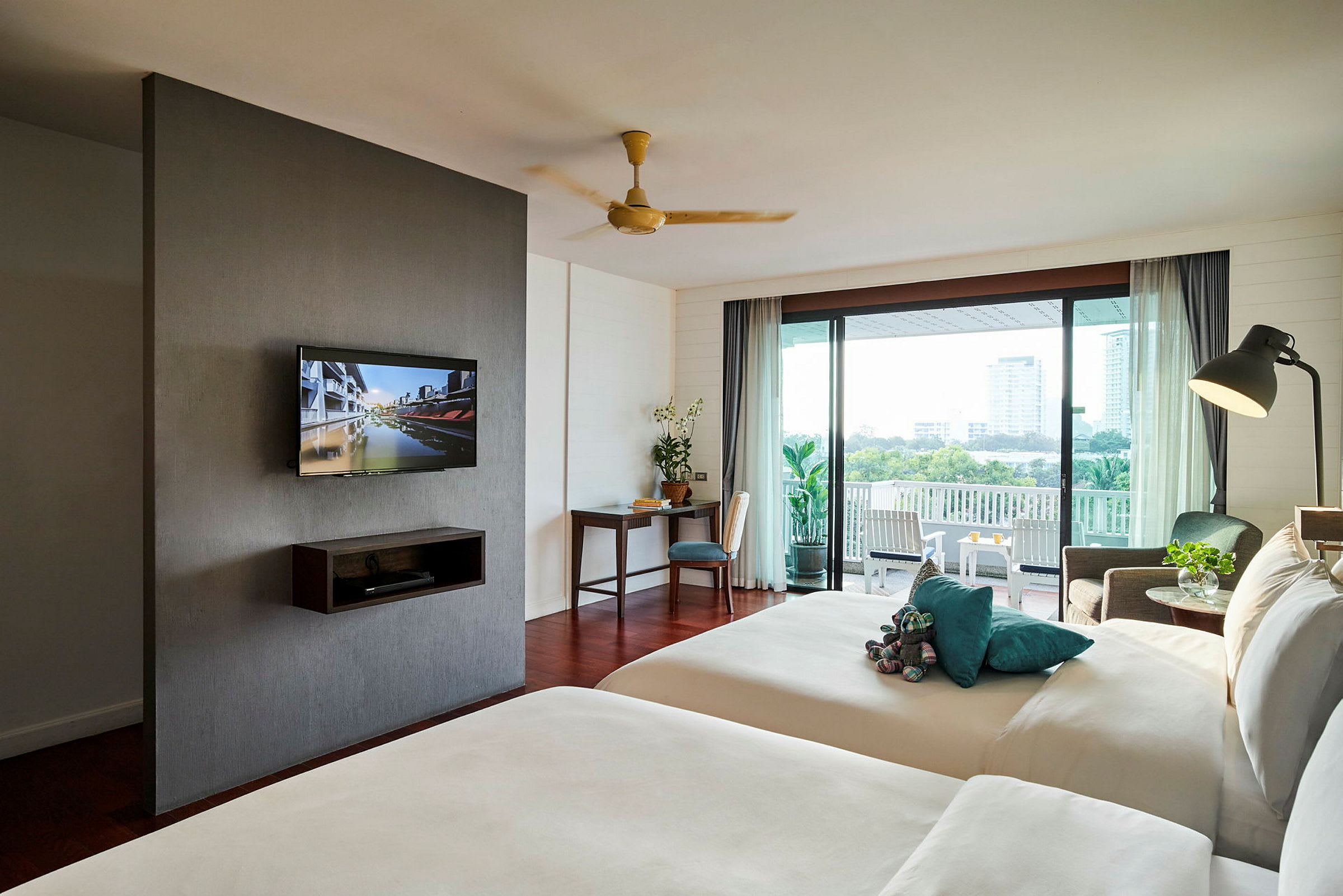 Ett hotellrum med två sängar, en TV på väggen och en balkong med utsikt. (AI-genererad text)