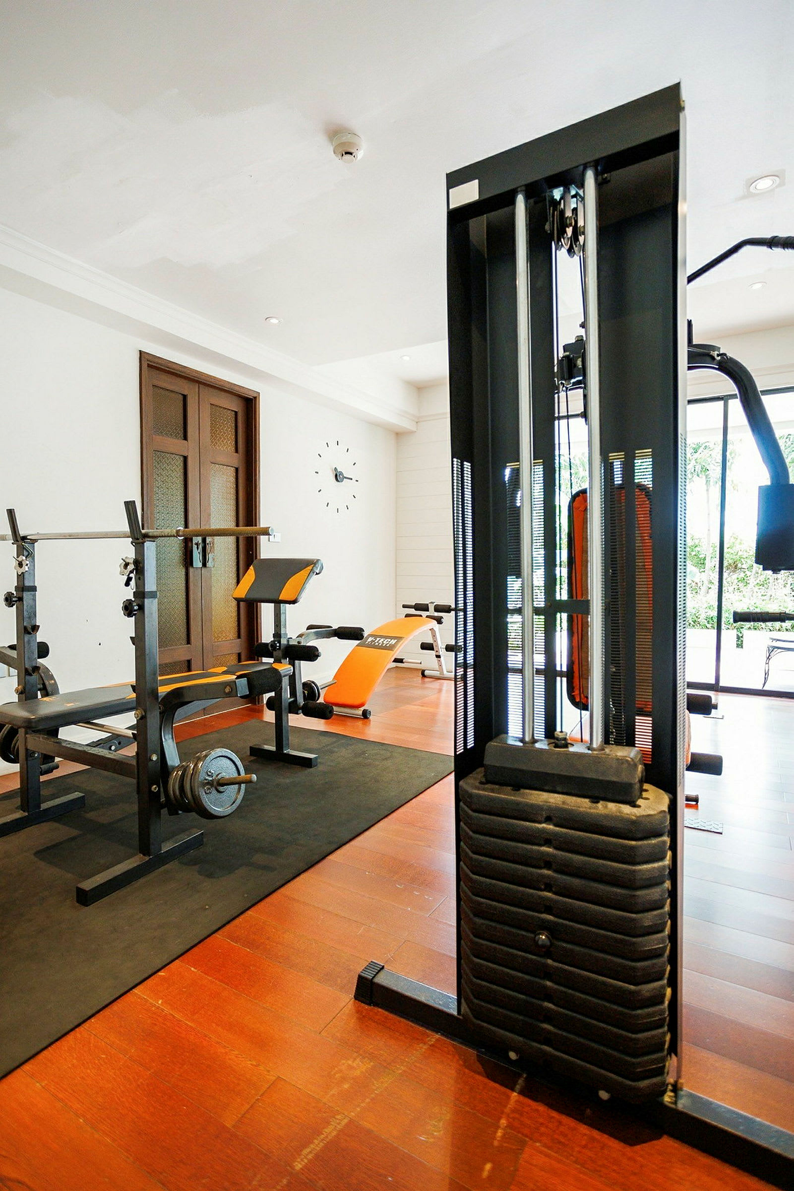 Bild av ett gym med träningsutrustning, inklusive bänkpress och kabelmaskin. (AI-genererad text)