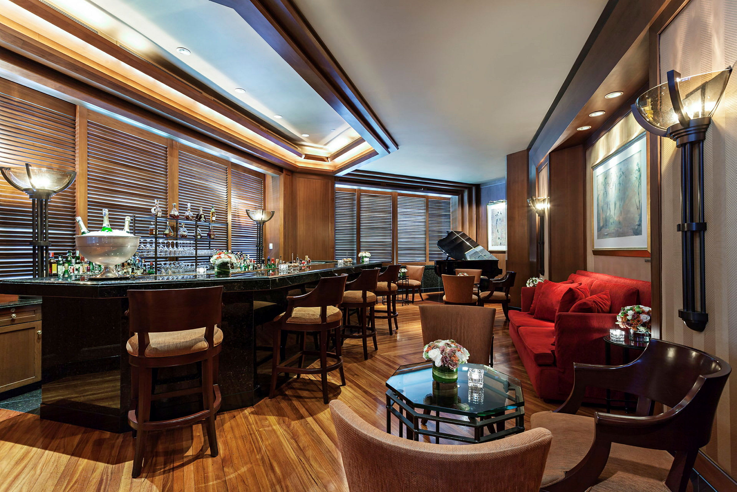 Ett elegant inrett loungeområde med en välkommen bar, bekväma sittplatser och ett piano i bakgrunden. (AI-genererad text)