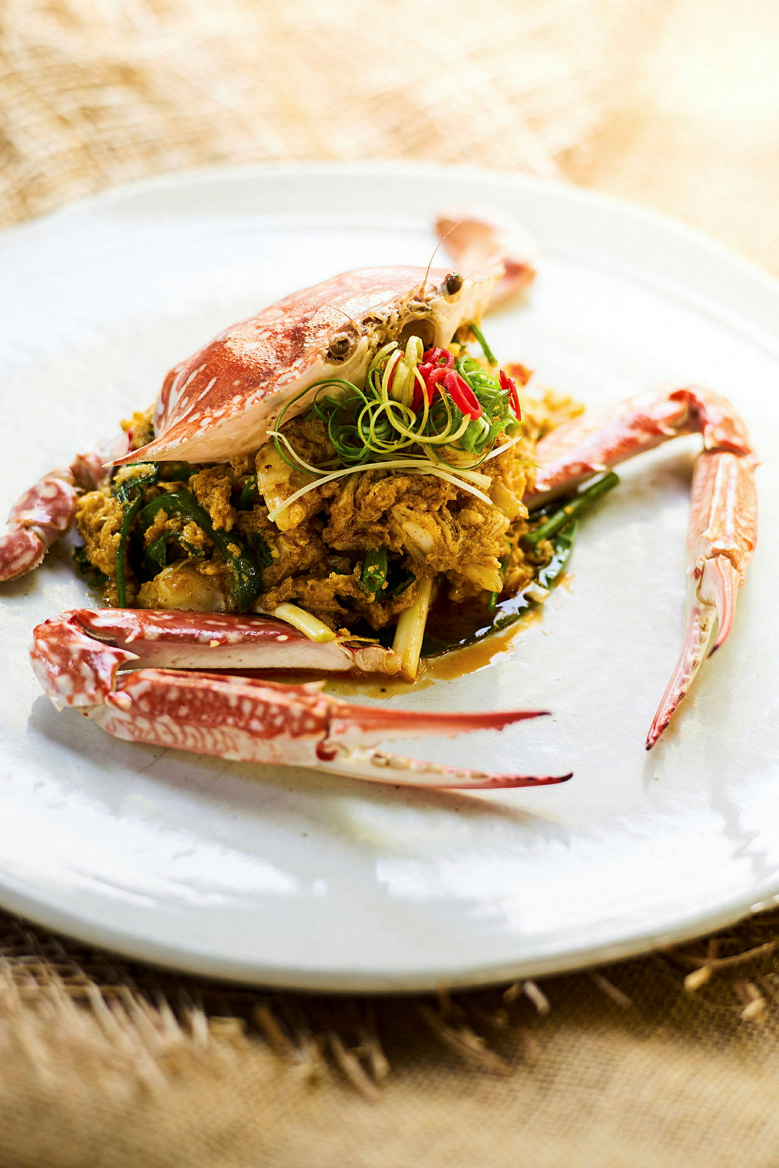 En tallrik med tillagad krabba och curry, dekorerad med grönsaker. (AI-genererad text)