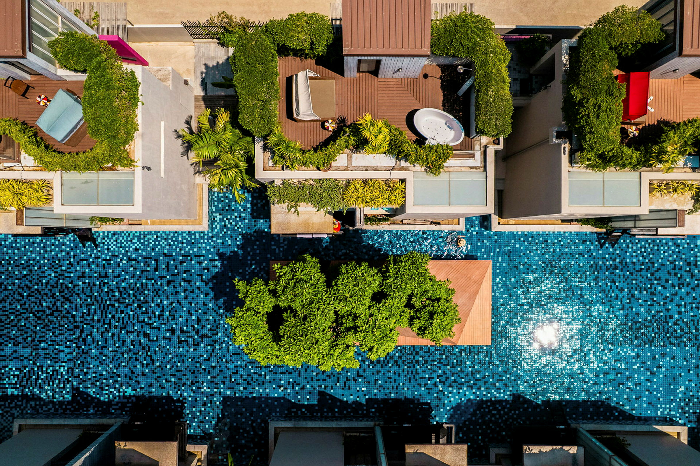 Flygvy över modernt boende med privata terrasser och poolområde. (AI-genererad text)