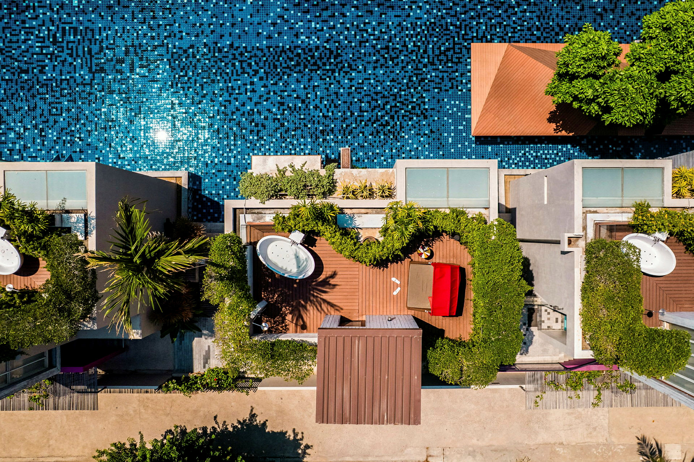 Fågelperspektiv av en utomhusmiljö med pool, trädgård och möblerade terrasser. (AI-genererad text)