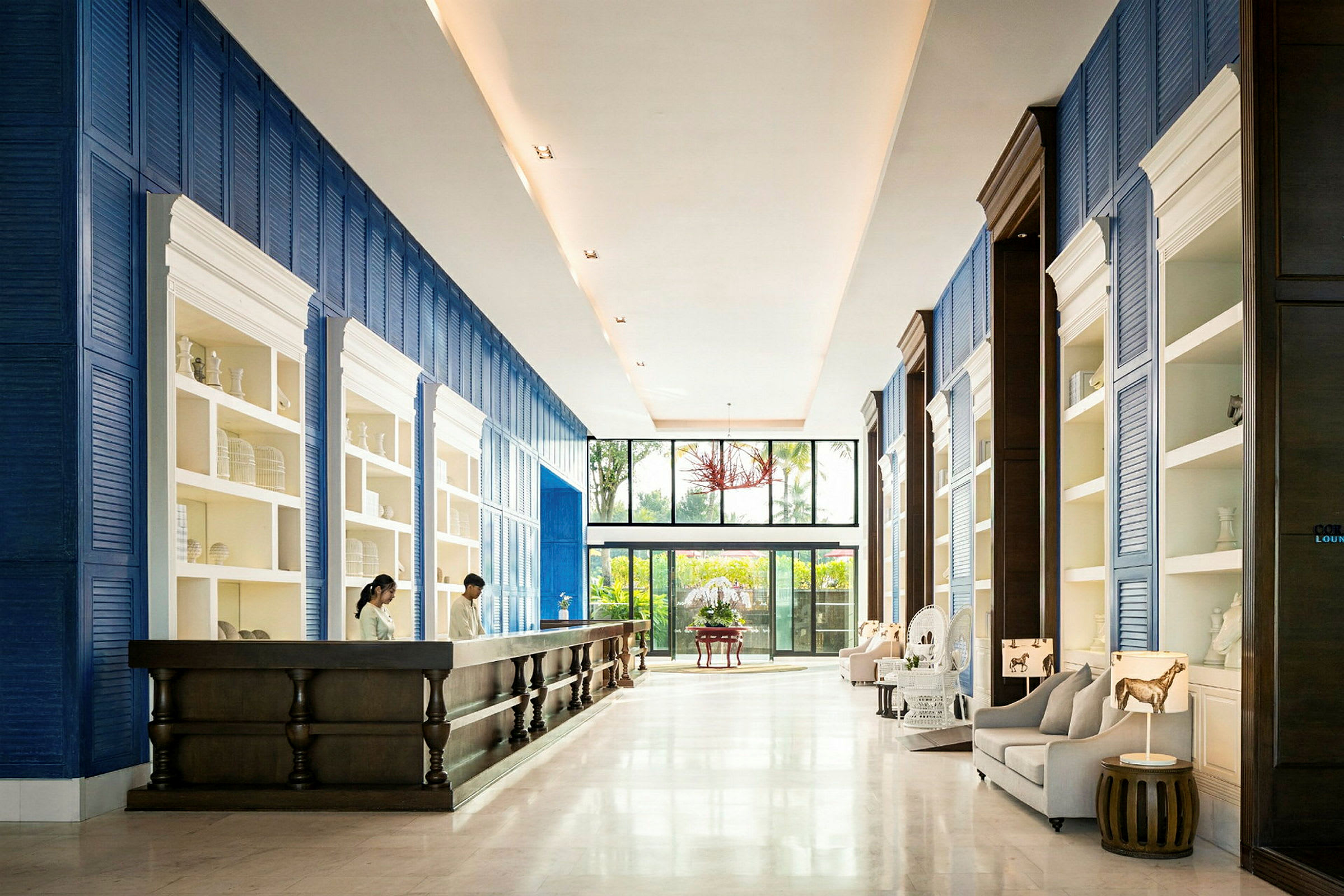Interiör av ett rymligt och elegant hotellobbyområde med blå-vita accenter, en receptionsdisk och sittplatser. (AI-genererad text)