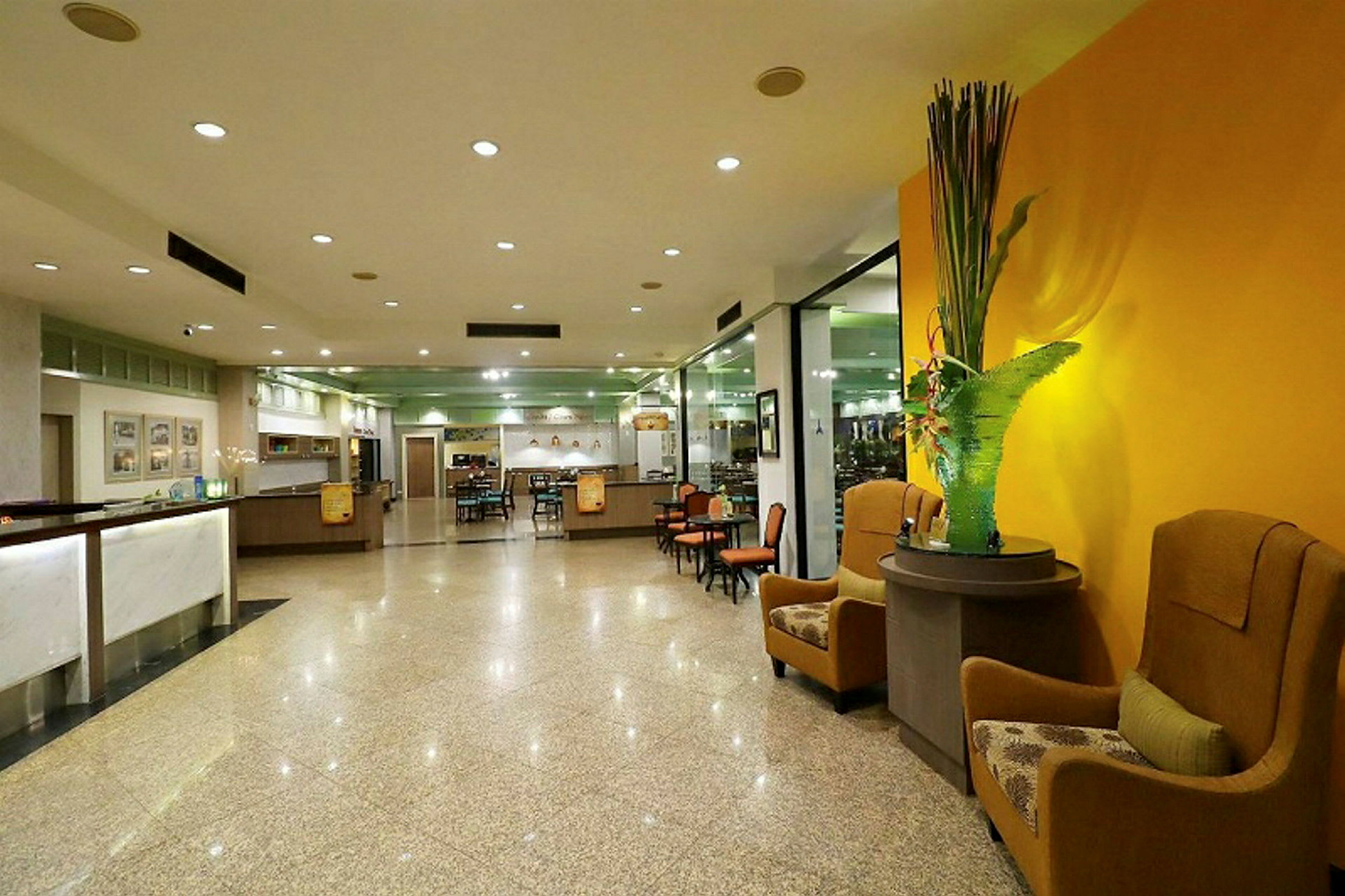 Ett modernt hotellobbyområde med sittplatser, reception och dekorativa element. (AI-genererad text)