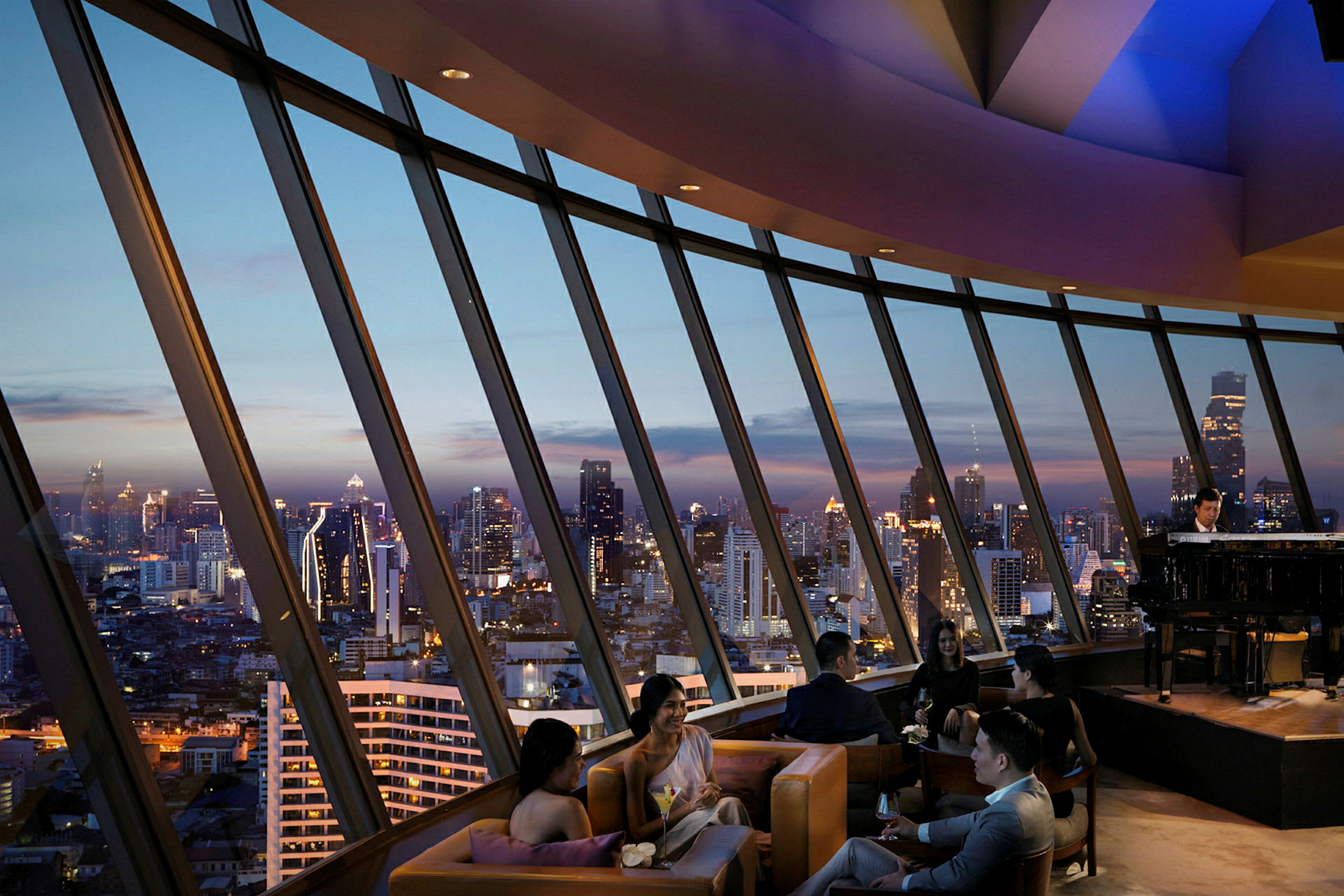 Folk sitter i en lyxig lounge med panoramavy över stadens skyline vid skymning. (AI-genererad text)