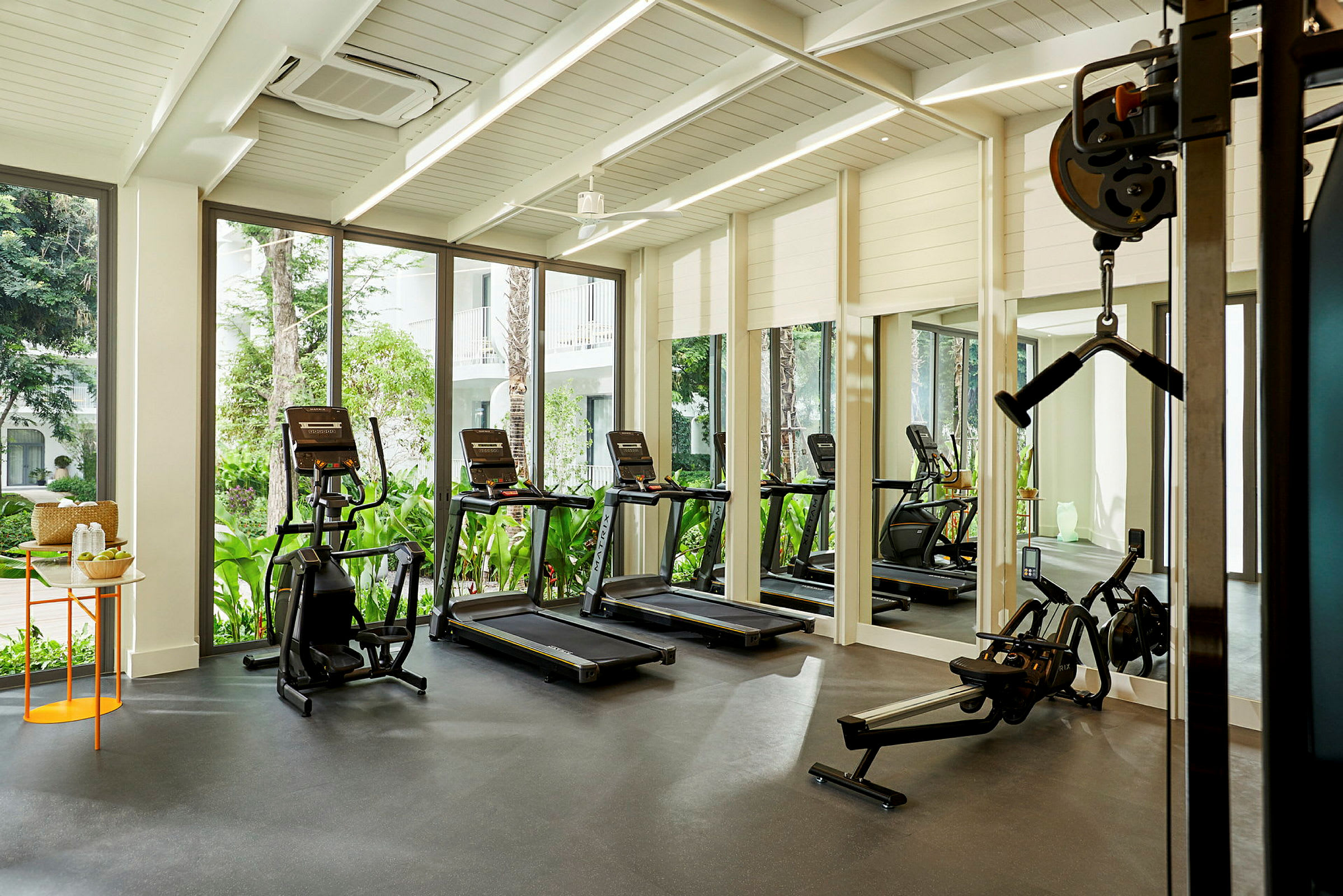 Modernt gym med träningsmaskiner, stora glasfönster och insläpp av naturligt ljus. (AI-genererad text)