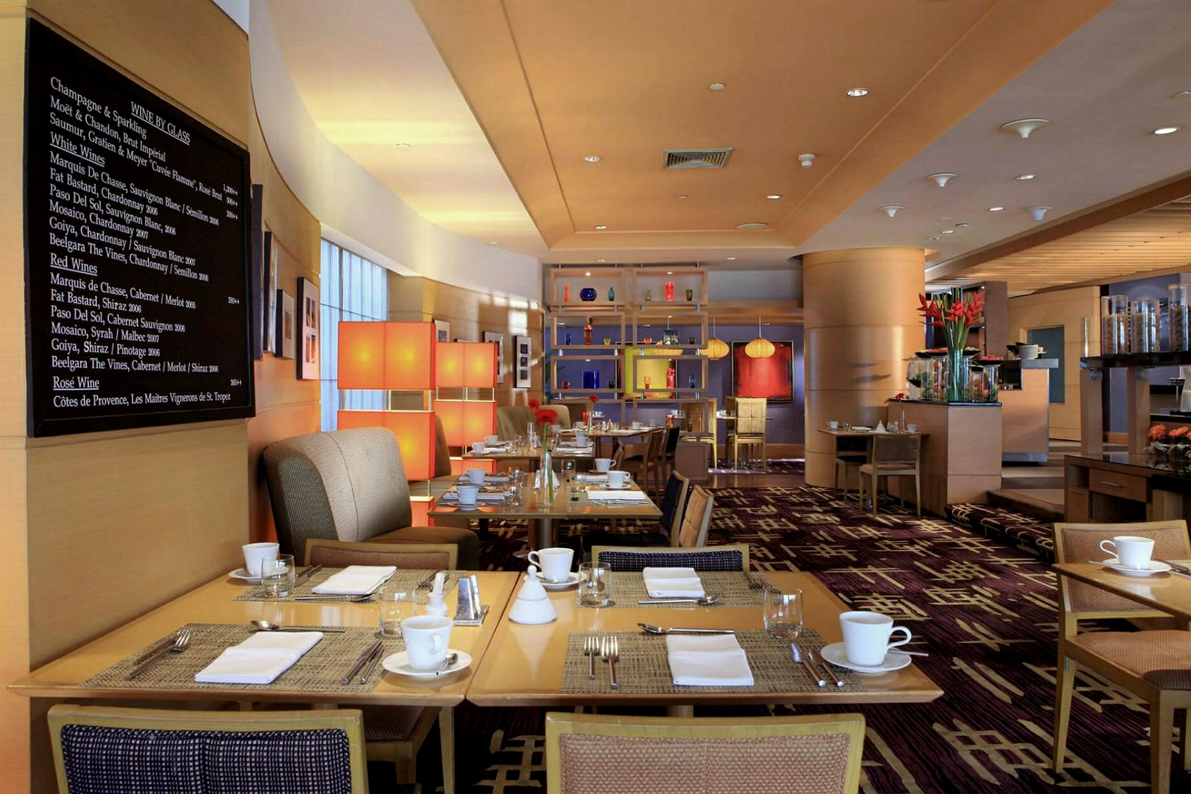 En modern och stilren restaurang med dukade bord och inredning i varma färger. (AI-genererad text)