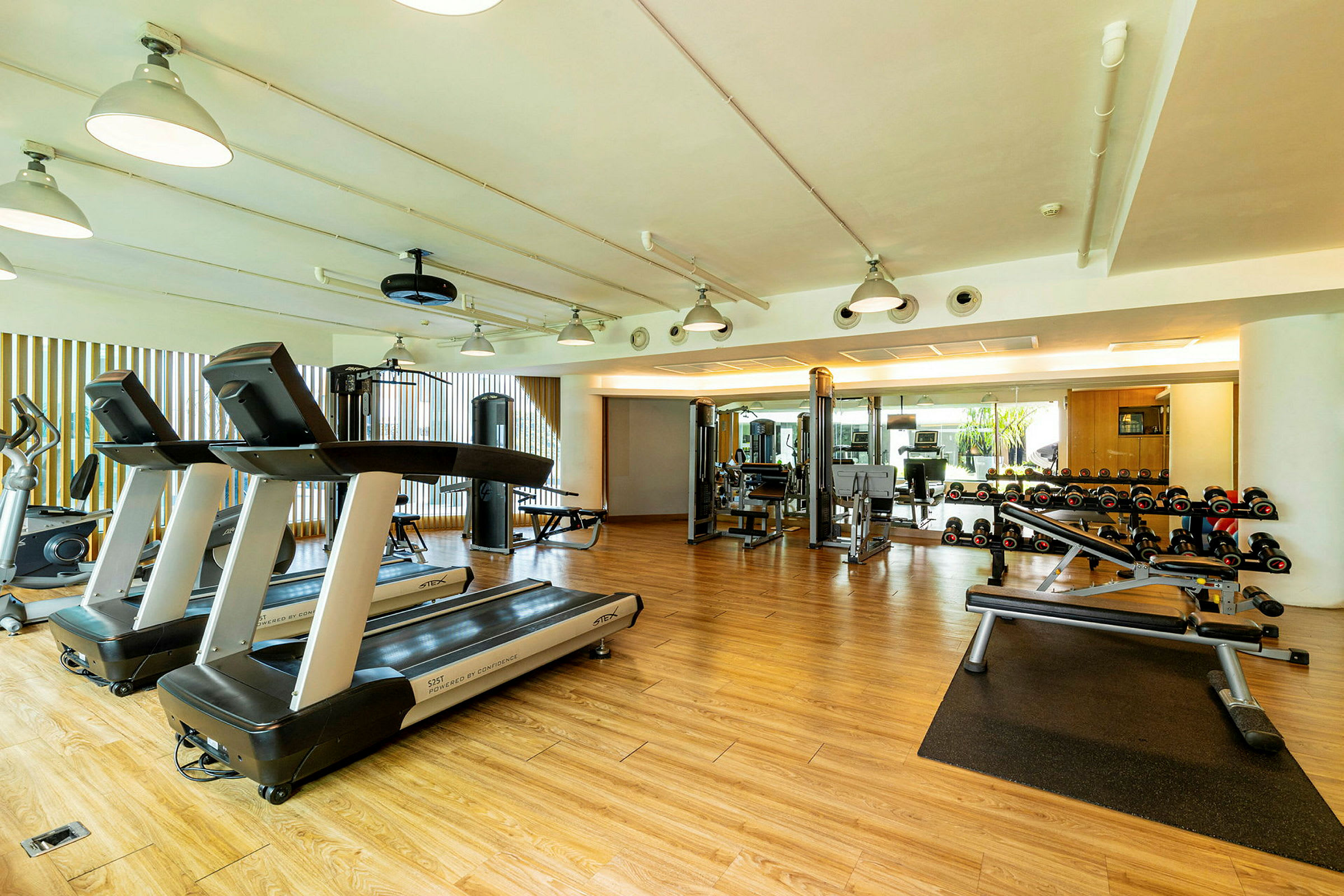 Ett gym med träningsmaskiner, löpband och hantlar. (AI-genererad text)