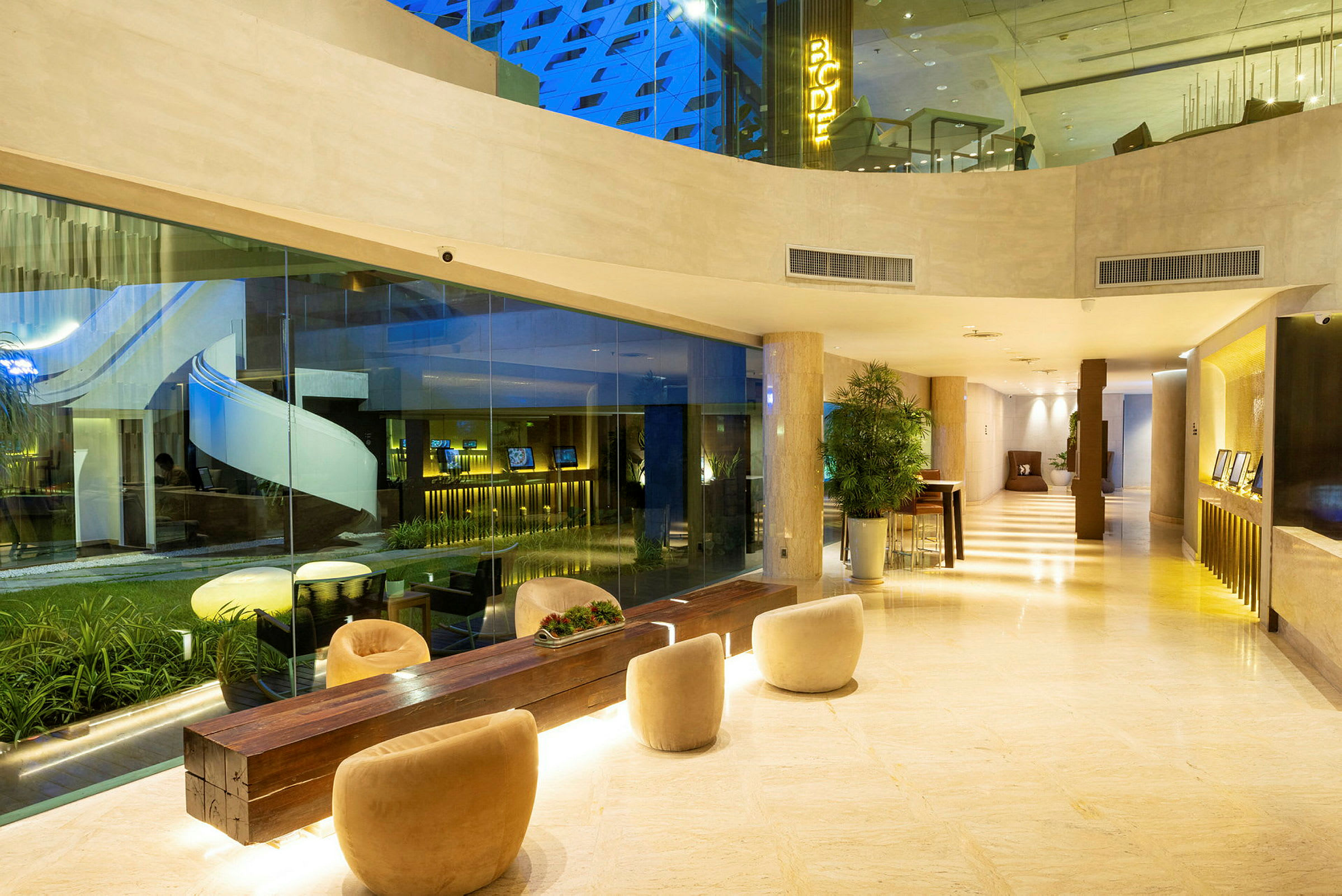 Hotellets lobbymiljö med sittplatser och glasväggar. (AI-genererad text)