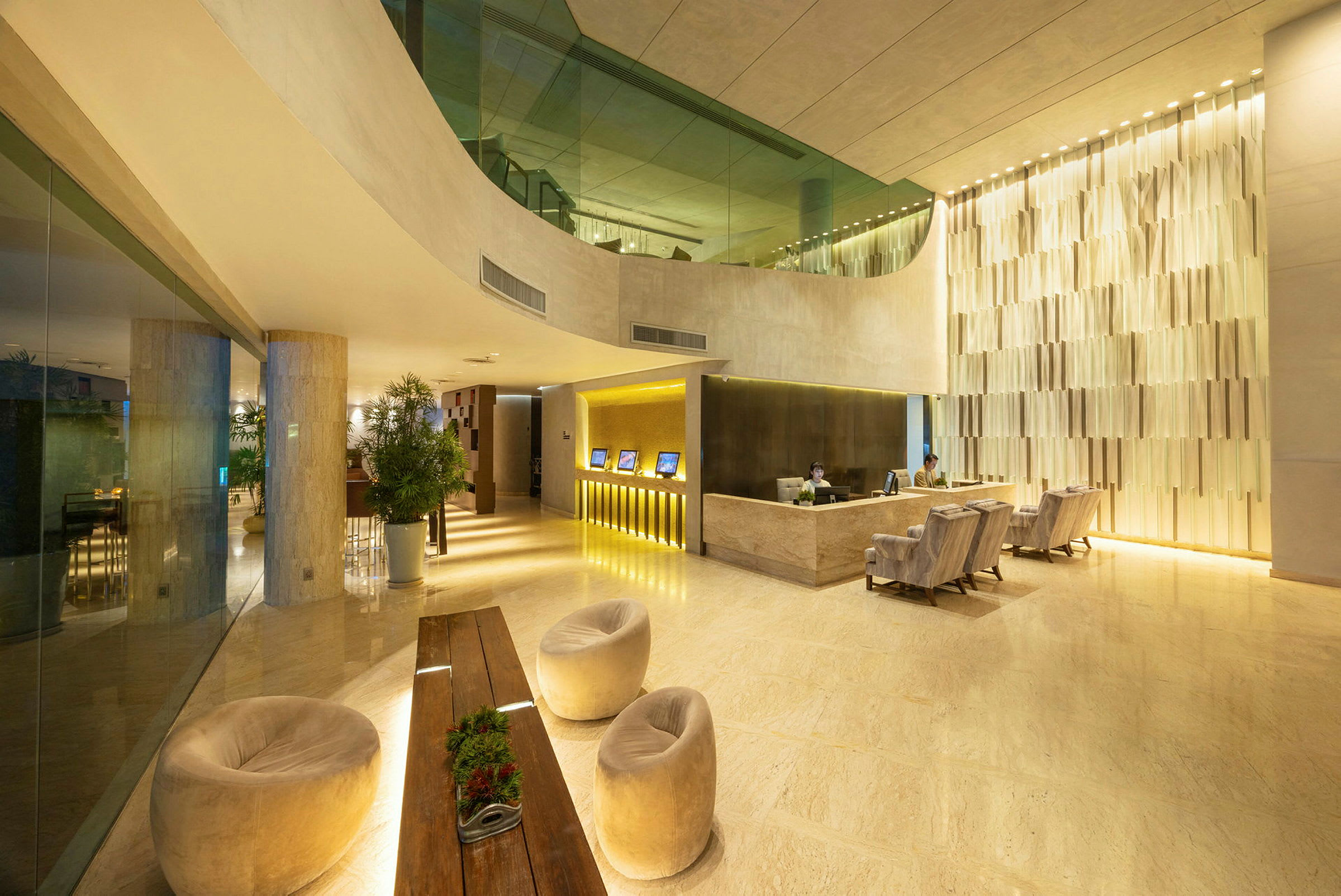 En modern hotellobby med reception, sittplatser och dekorativa växter. (AI-genererad text)