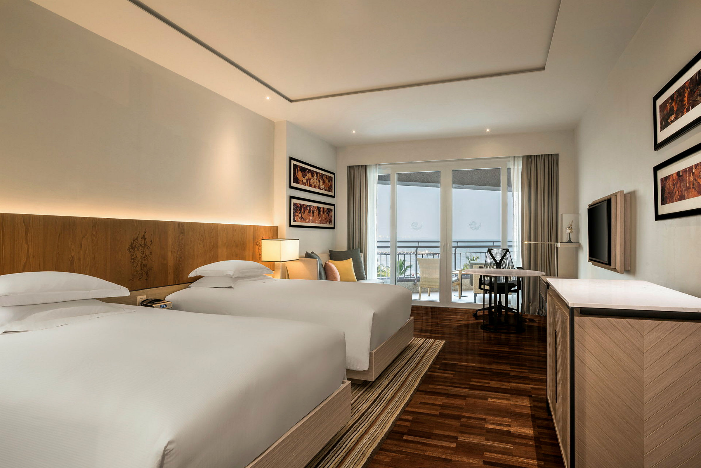 Hotellrum med två sängar, modern inredning och balkong i bakgrunden. (AI-genererad text)