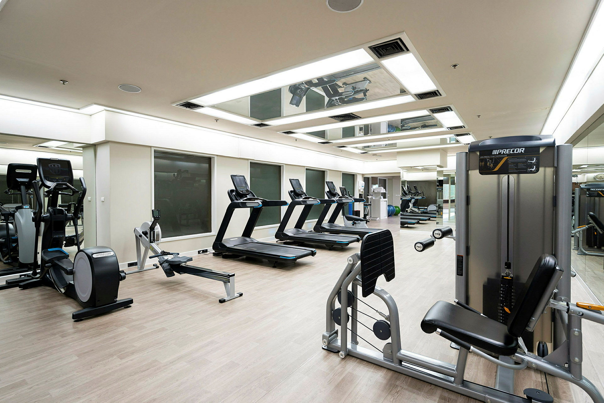 Ett gym med träningsmaskiner som löpband, roddmaskiner och styrketräningsutrustning. (AI-genererad text)