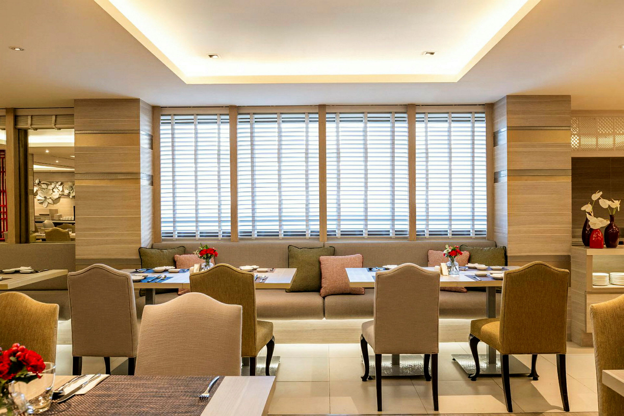 Bild av en modern restaurang med eleganta stolar och bord samt soffplatser, dekorerade med färska blommor. (AI-genererad text)