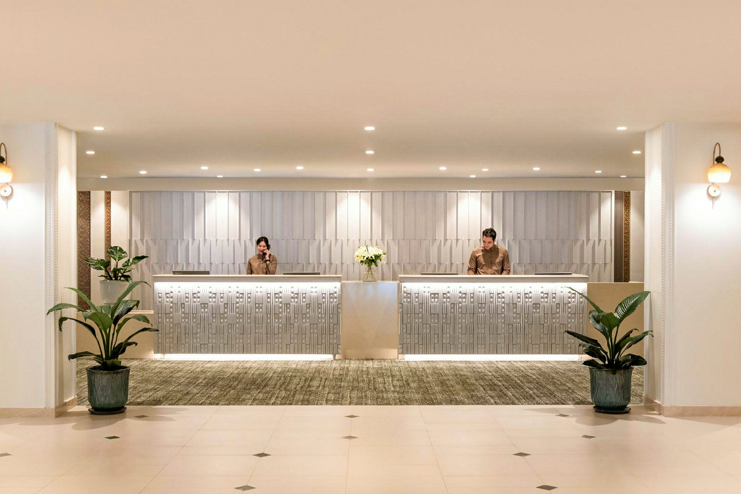 Reception med två receptionister, modern inredning och växter. (AI-genererad text)
