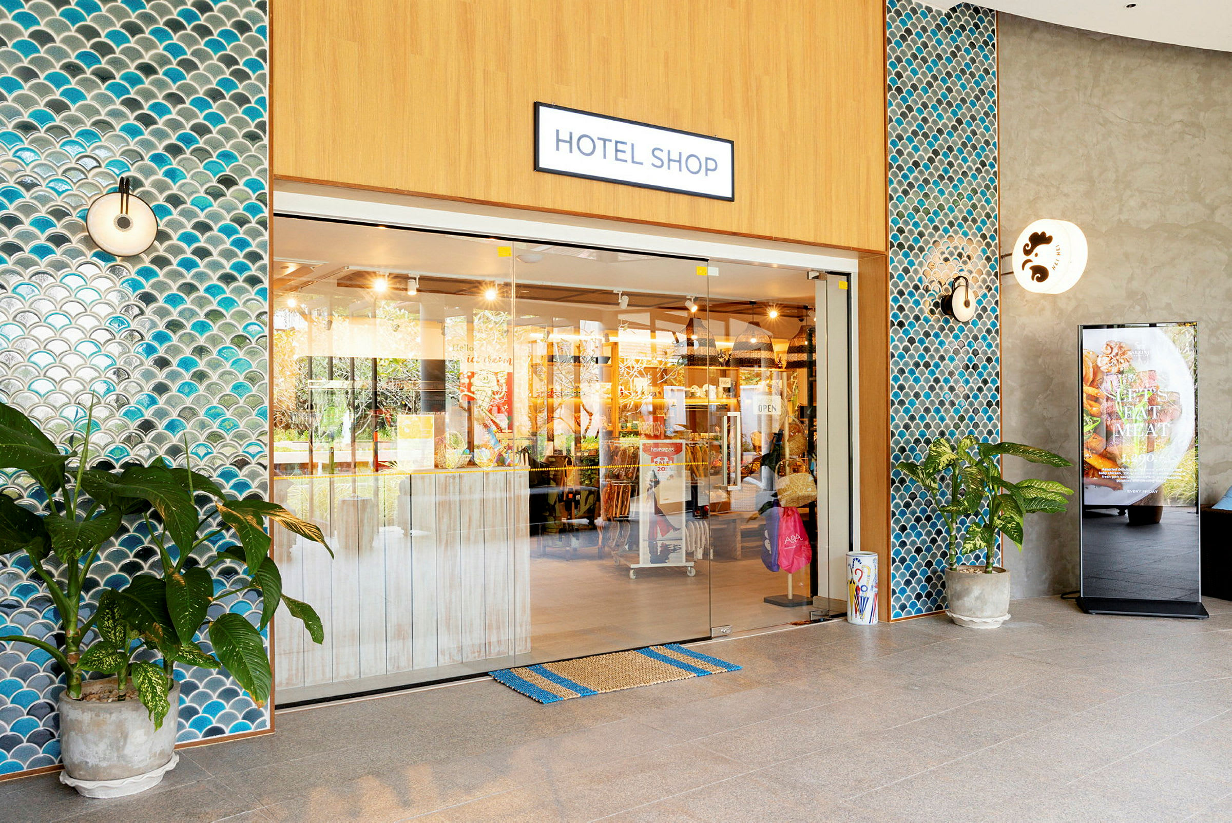 Ingången till en hotellbutik med glasdörrar och kaklade väggar. (AI-genererad text)
