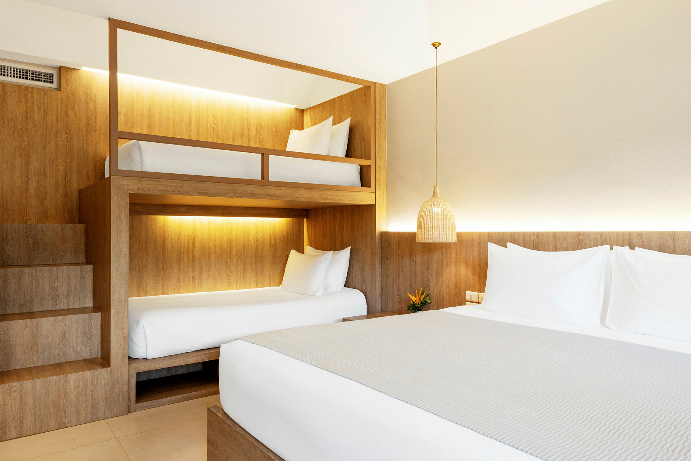 Ett hotellrum med en dubbelsäng och våningssängar. (AI-genererad text)