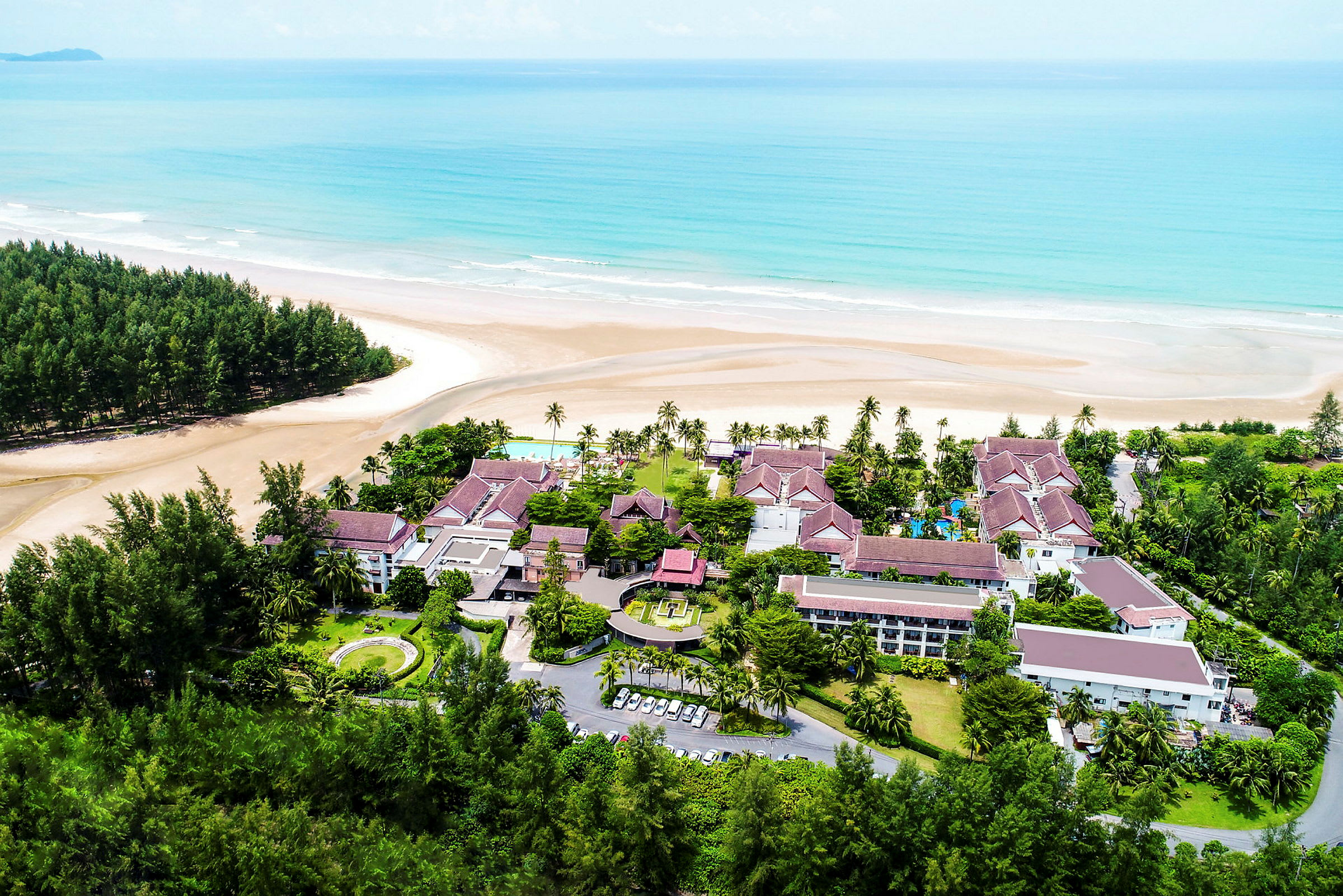 Semesterresort vid en bred sandstrand och klart blått hav. (AI-genererad text)