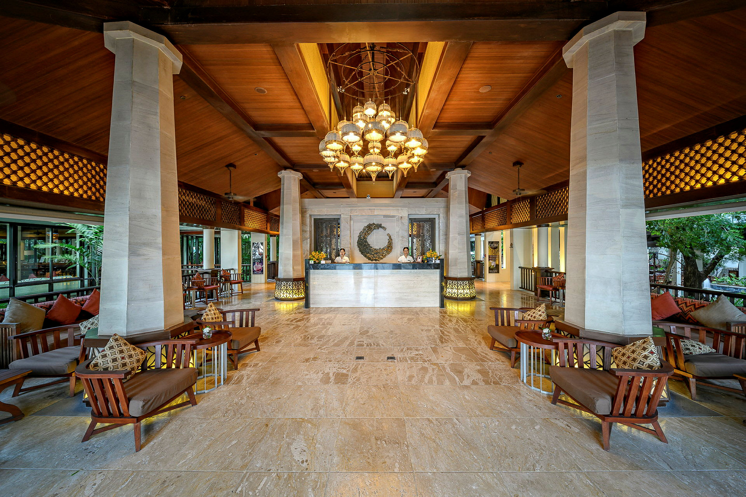 En öppen och elegant hotellobby med högt trätak, marmorgolv, sittplatser och en reception. (AI-genererad text)