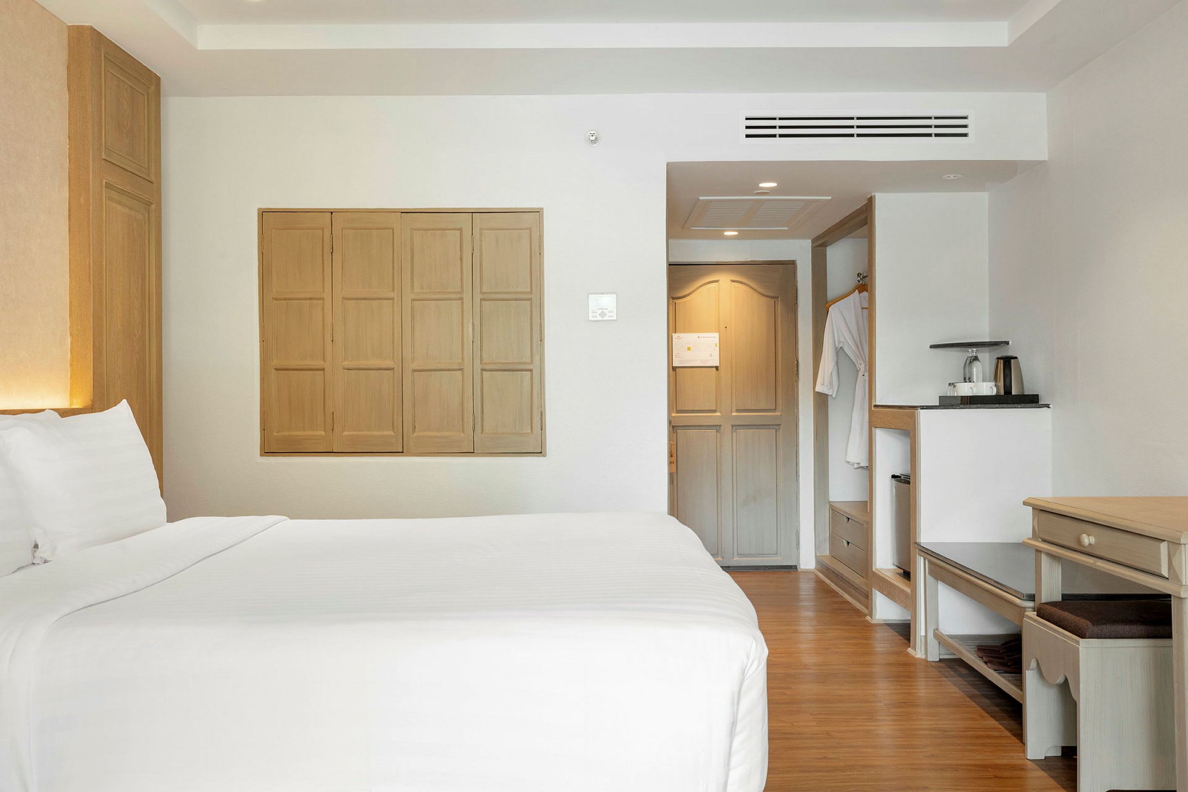 Hotellrum med dubbelsäng, sittmöbler och varm inredning. (AI-genererad text)