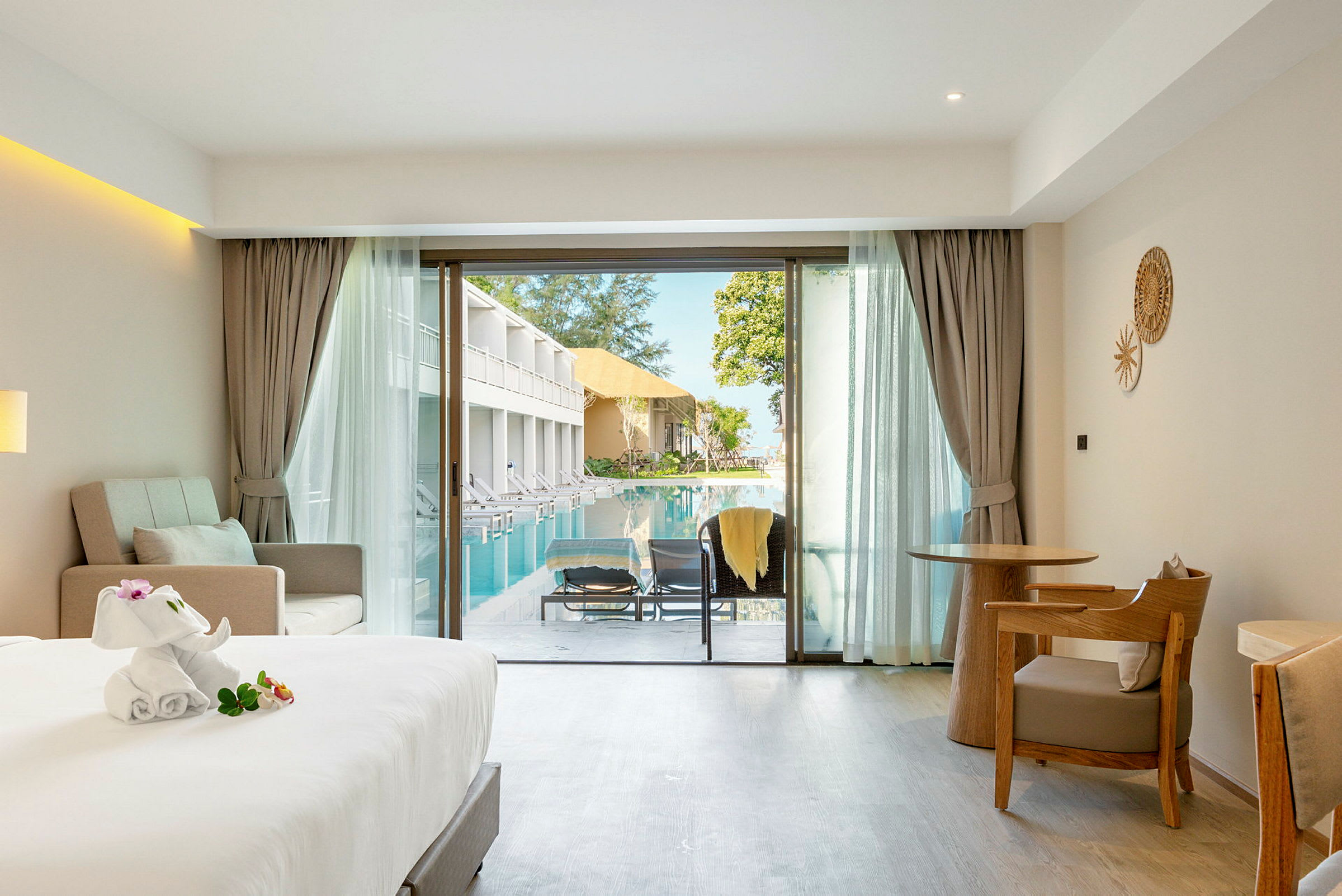 Hotellrum med balkong som vetter mot en pool. (AI-genererad text)